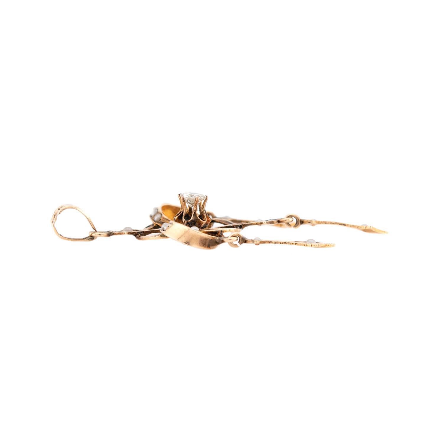 A lovely lavalier pendant from the Edwardian (ca1910s) era! Crafted in 14k yellow gold, this pendant features a unique interlocking-knot motif. The center of the knots feature a .15ct six-prong set old mine cut diamond. The knots are connected to