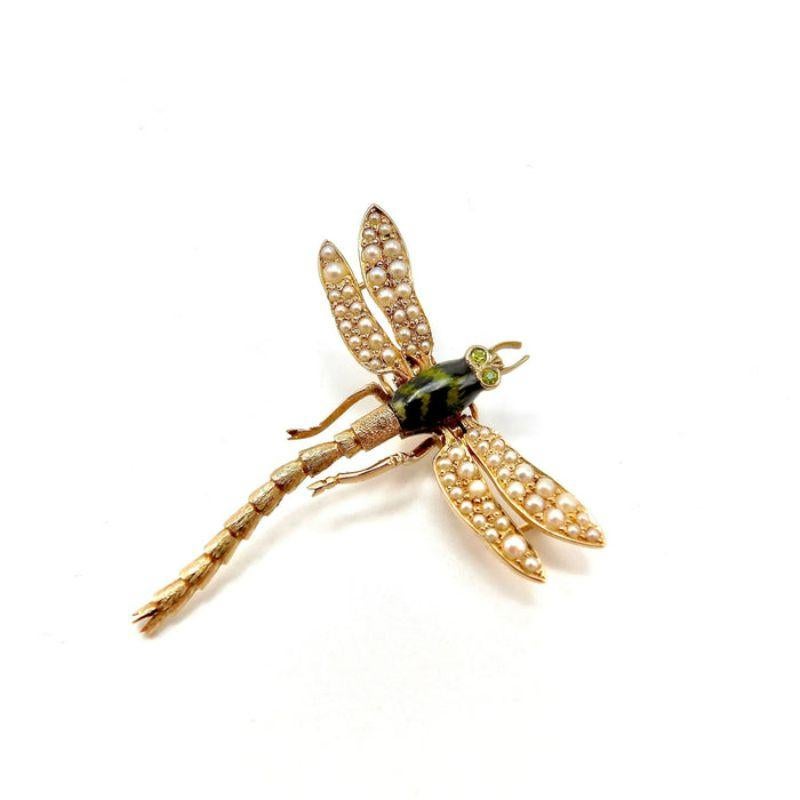 A stunning dragonfly pendant, beautifully articulated, textured and studded. The dragonfly is a lovely work of art; made of 14 karat yellow gold it has a dark blue and green hand-painted enamel body, with tiny seed pearls on its fluttering wings,