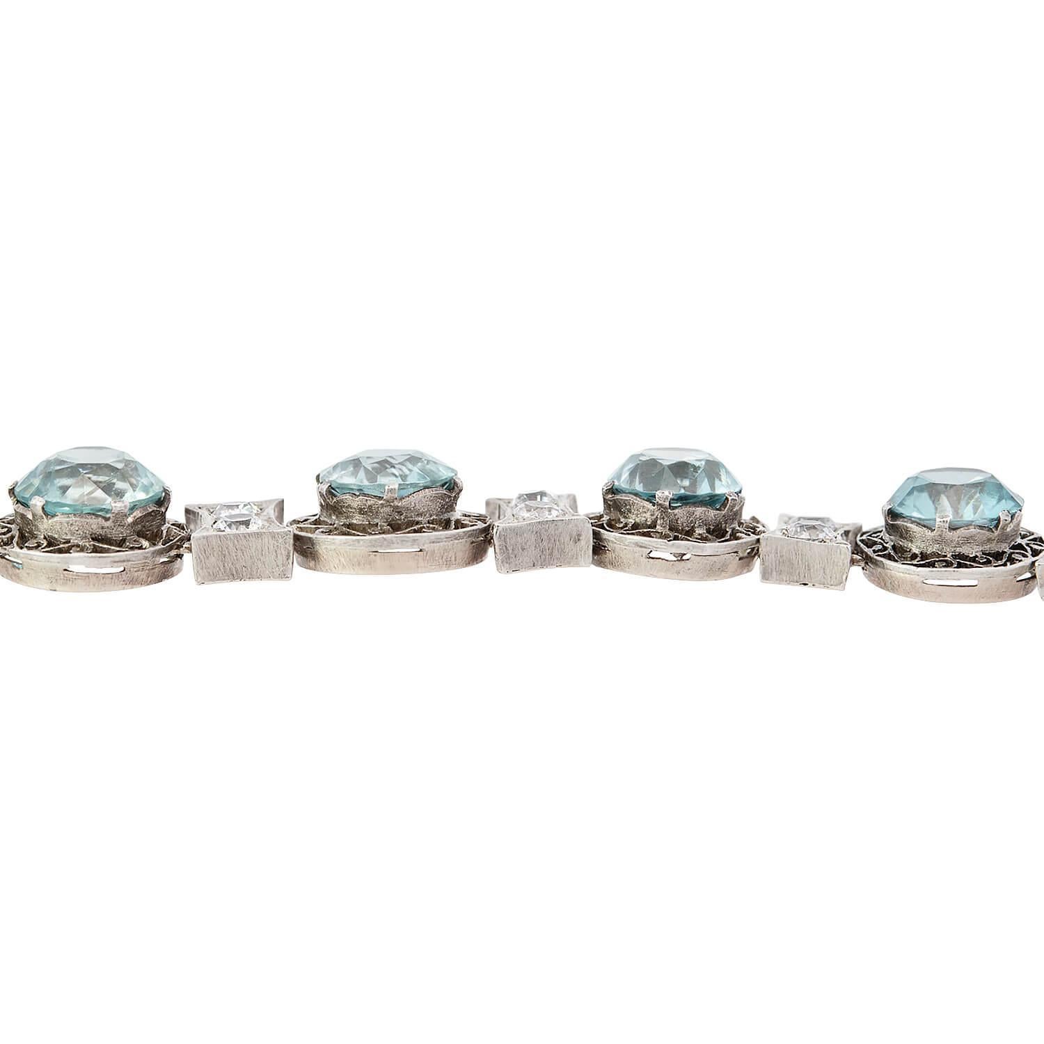 Un fabuleux bracelet en zircon de l'époque édouardienne (ca1910s) ! Cette magnifique pièce est réalisée en or blanc et en argent sterling et se compose de 12 zircons bleus, chacun étant serti individuellement dans une monture de type 