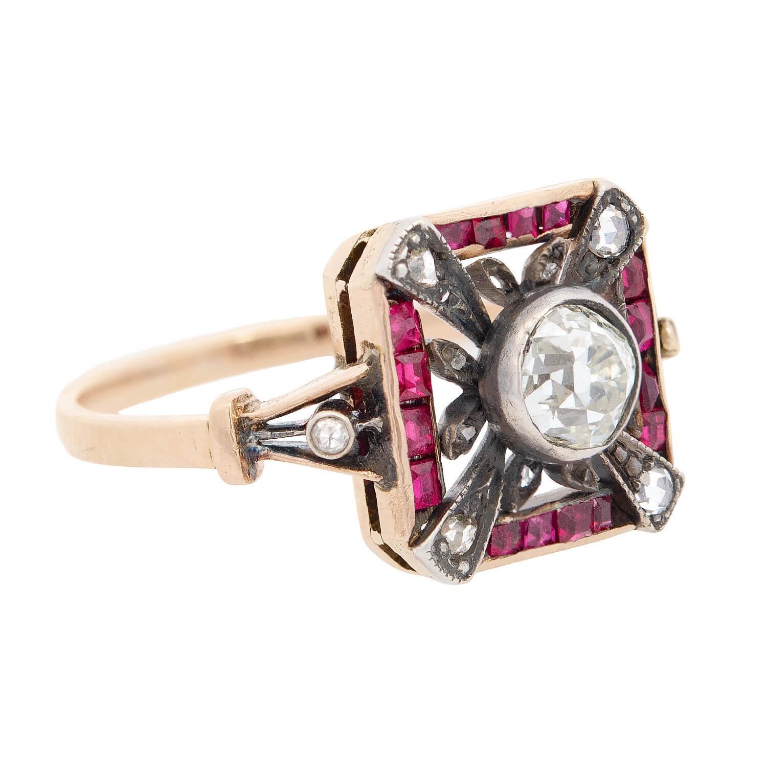 A very unique diamond and ruby ring from the Edwardian (ca1910s) era! This unique ring is crafted in 14k gold and sterling silver, and features a square-shaped centerpiece. The square is centered by a bezel set old mine cut diamond. Radiating out