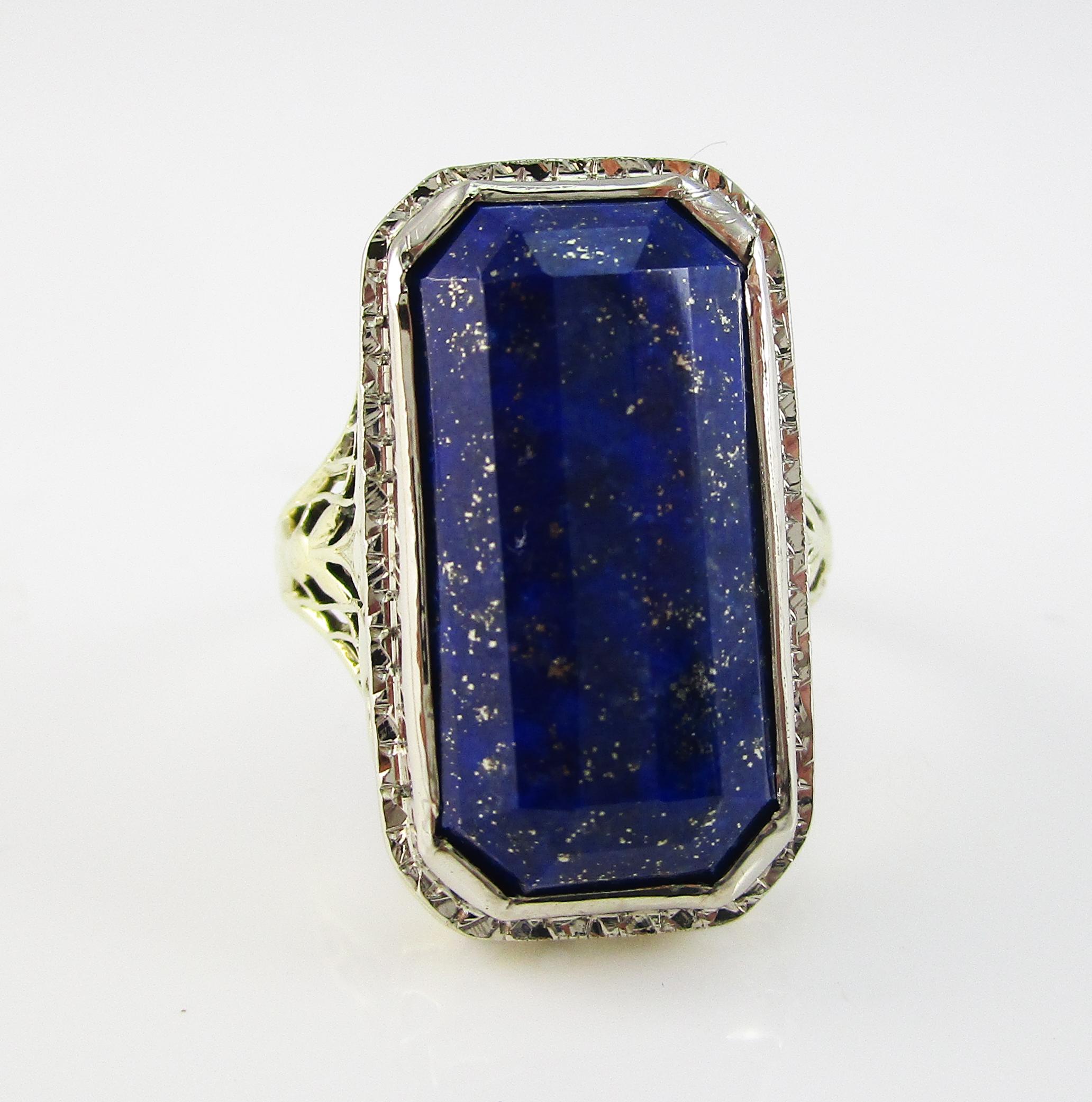 This is a remarkable Edwardian ring in 14k white and green gold with stunning filigree details and a gorgeous faceted natural blue lapis center stone! The under gallery and shank of the ring are in green gold and boast incredible filigree work. The