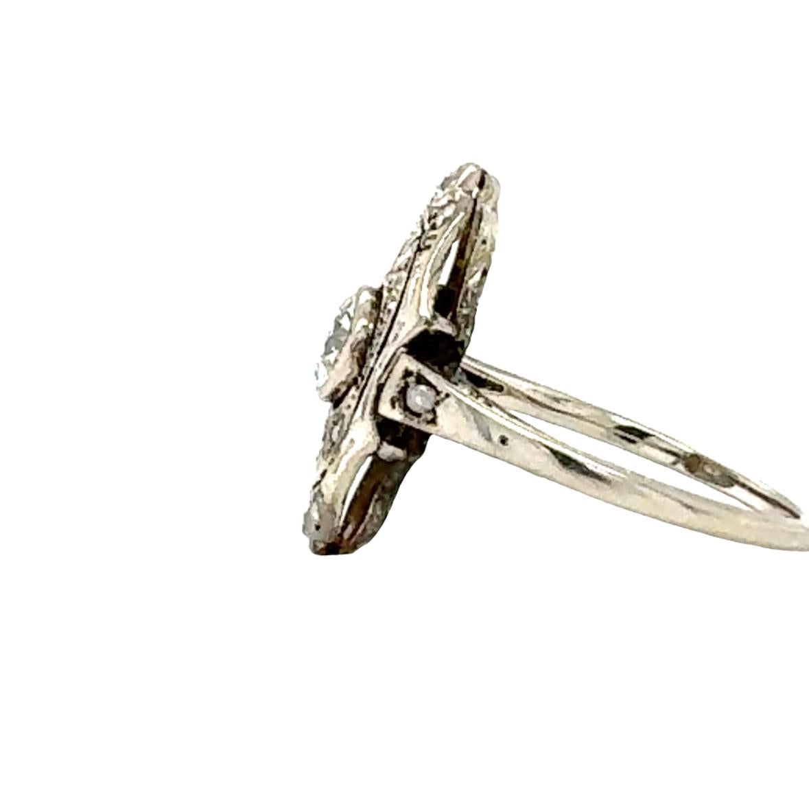 This delicate Edwardian filigree ring, crafted in 14K white gold, captures the refined elegance of the 1910s. At its center, a bezel-set old mine cut diamond weighing 0.45 carats shines with L-M color and SI-1 clarity, offering a subtle warmth and
