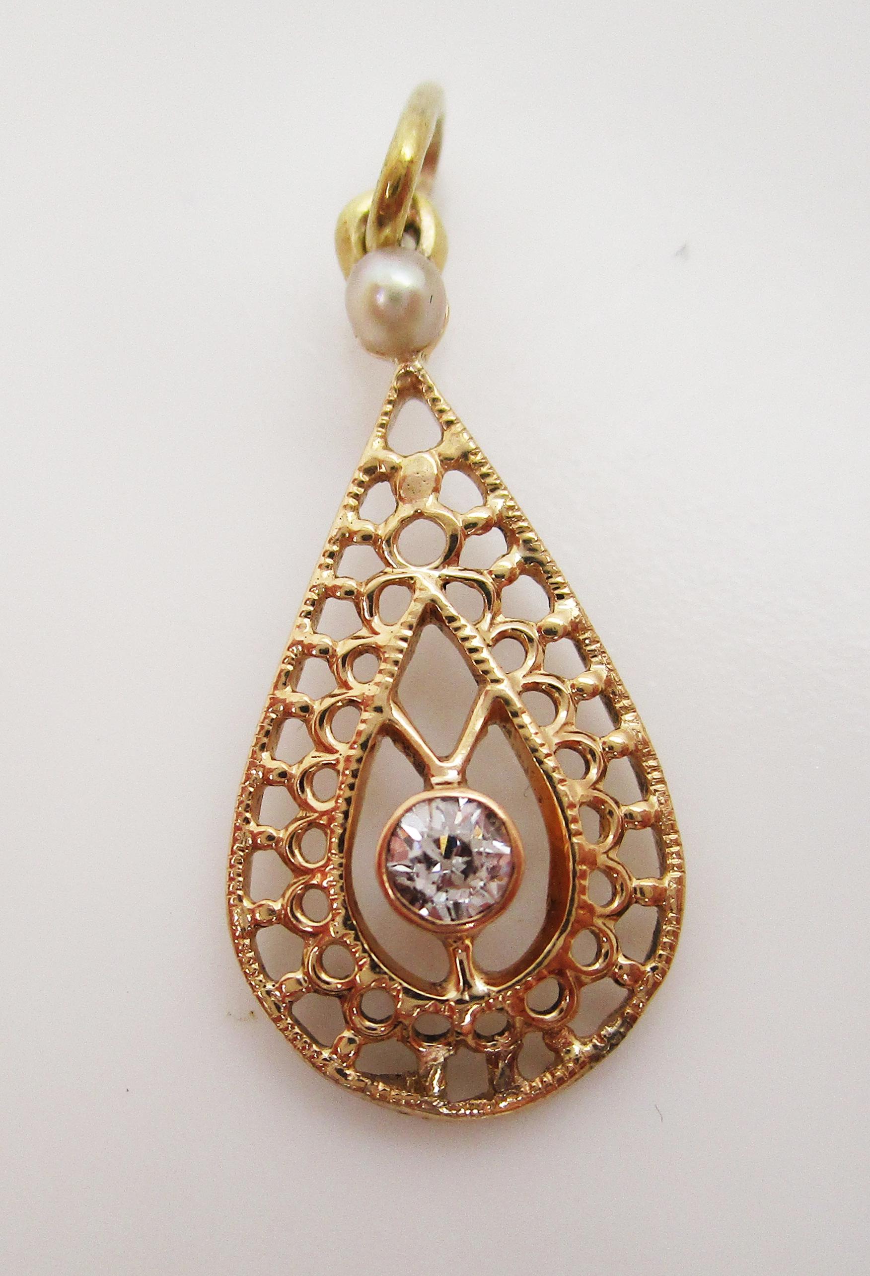 This lovely Edwardian pendant is in 14k yellow gold and features both a seed pearl and delicate diamond accent in an open pear design! The open design of the pendant creates a lacy look that is delicate and beautiful! At the top of the pendant sits