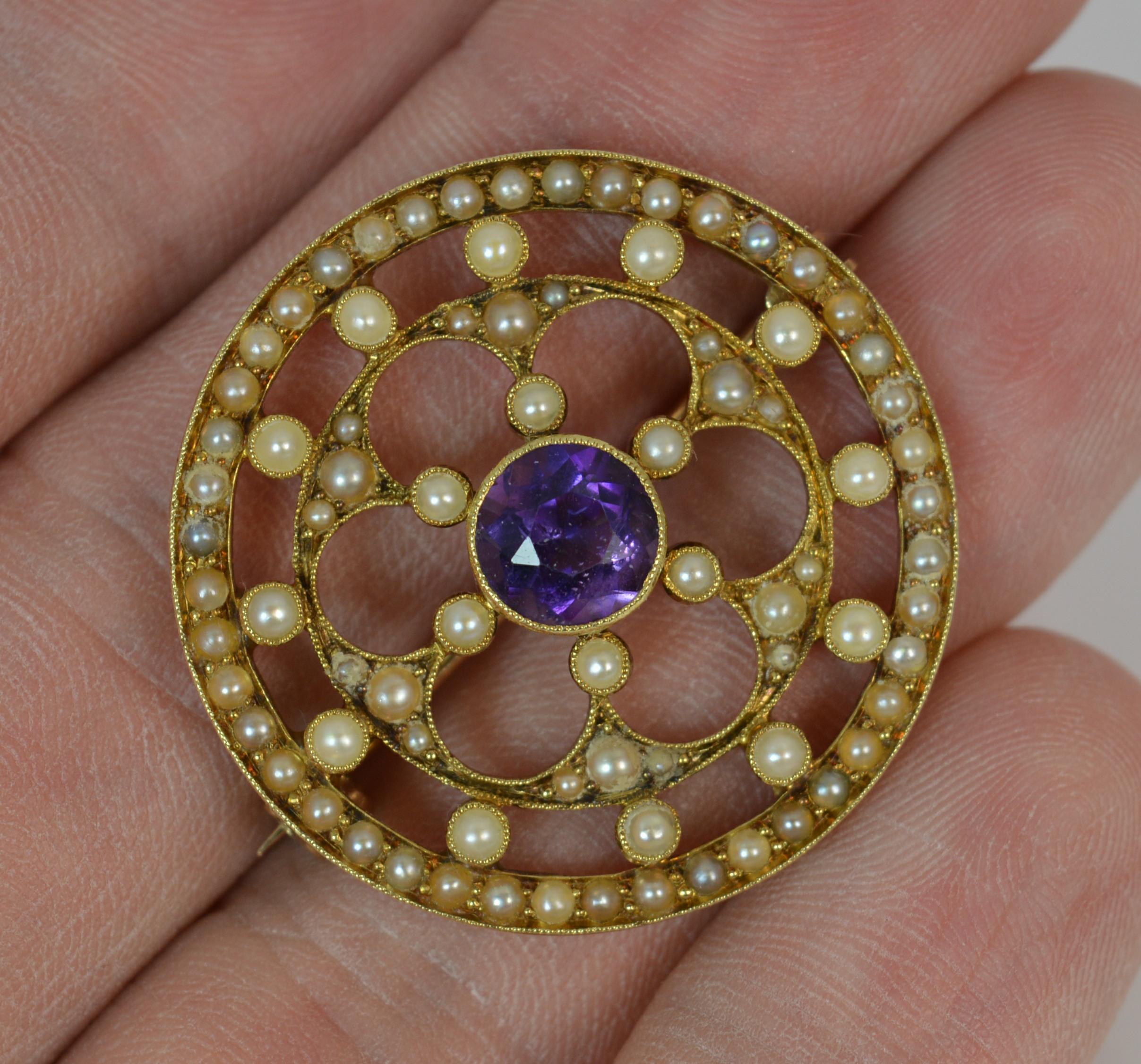 
A fantastic quality Edwardian period brooch.

Solid 15 carat yellow gold example.

Set with a 6.8mm diameter amethyst to the centre with multiple seed pearls surrounding to the symetrical circular panel disc piece.

Purple and white