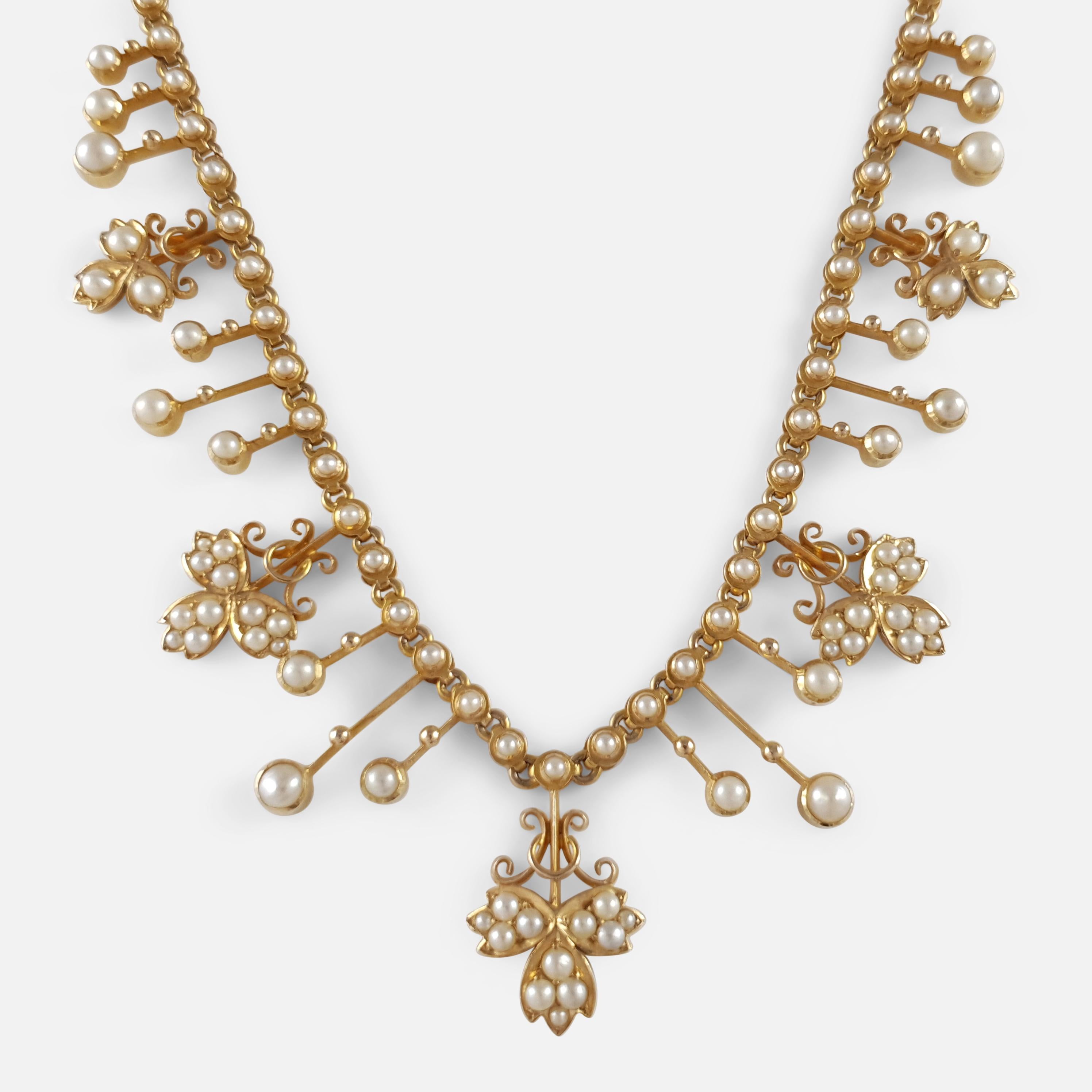 Description: - This is a fine antique Edwardian 15 karat yellow gold seed pearl necklace. The necklace is crafted with fringe and foliate motifs set with seed pearls, to a chain adorned with a seed pearl to each link, complete with push in clasp.