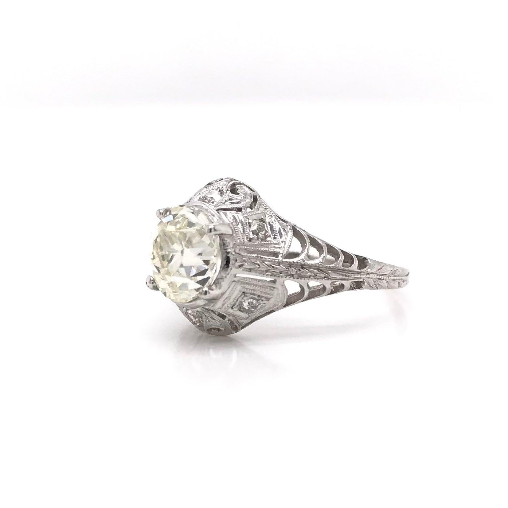 This gorgeous antique piece was handcrafted sometime during the Edwardian design period ( 1900-1920 ). The setting is platinum and features a beautiful center diamond measuring approximately 1.50 carats. The center diamond is an old European cut and