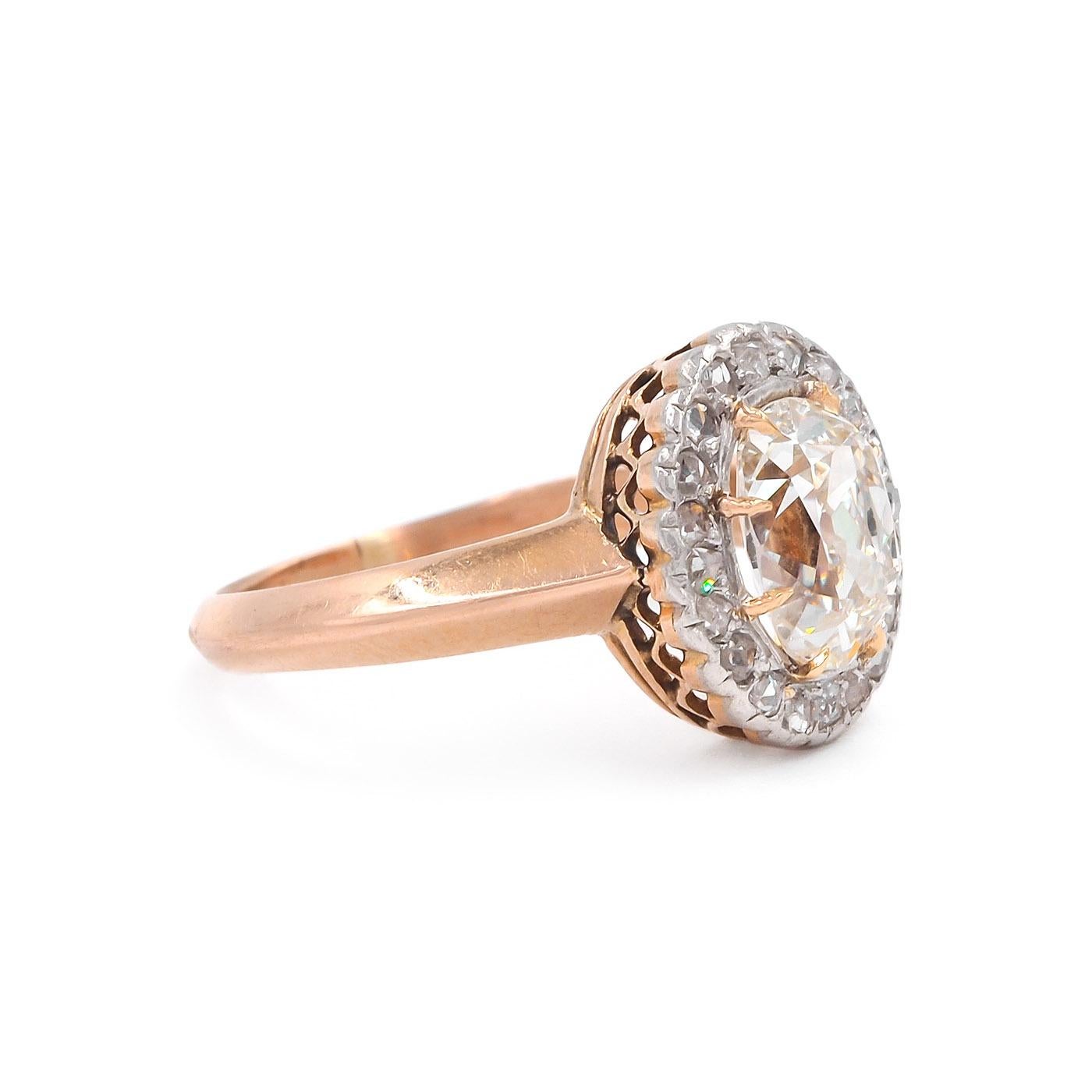 Edwardian era  Old Mine Cushion Cut Diamond Cluster Engagement Ring composed of 18k light rose gold and platinum. Featuring a 1.52 Carat elongated Old Mine Cut diamond, GIA certified K color & VS2 clarity. The center diamond is surrounded by 20 Rose