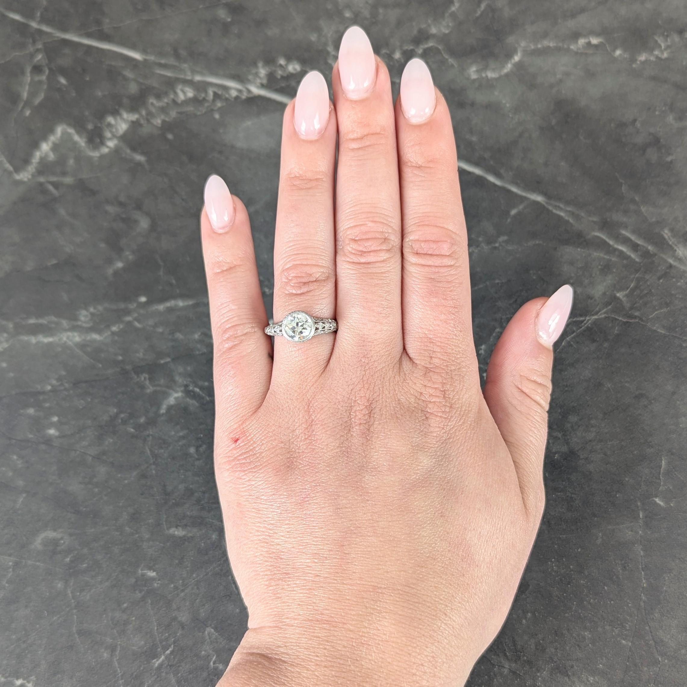 Centering an old European cut diamond weighing approximately 1.17 carat - K color with VS2 clarity
Set in an engraved wheat laurel motif and milgrain bezel with pierced gallery surround
Depicting foliates and lily-of-the-valley bead and bezel set