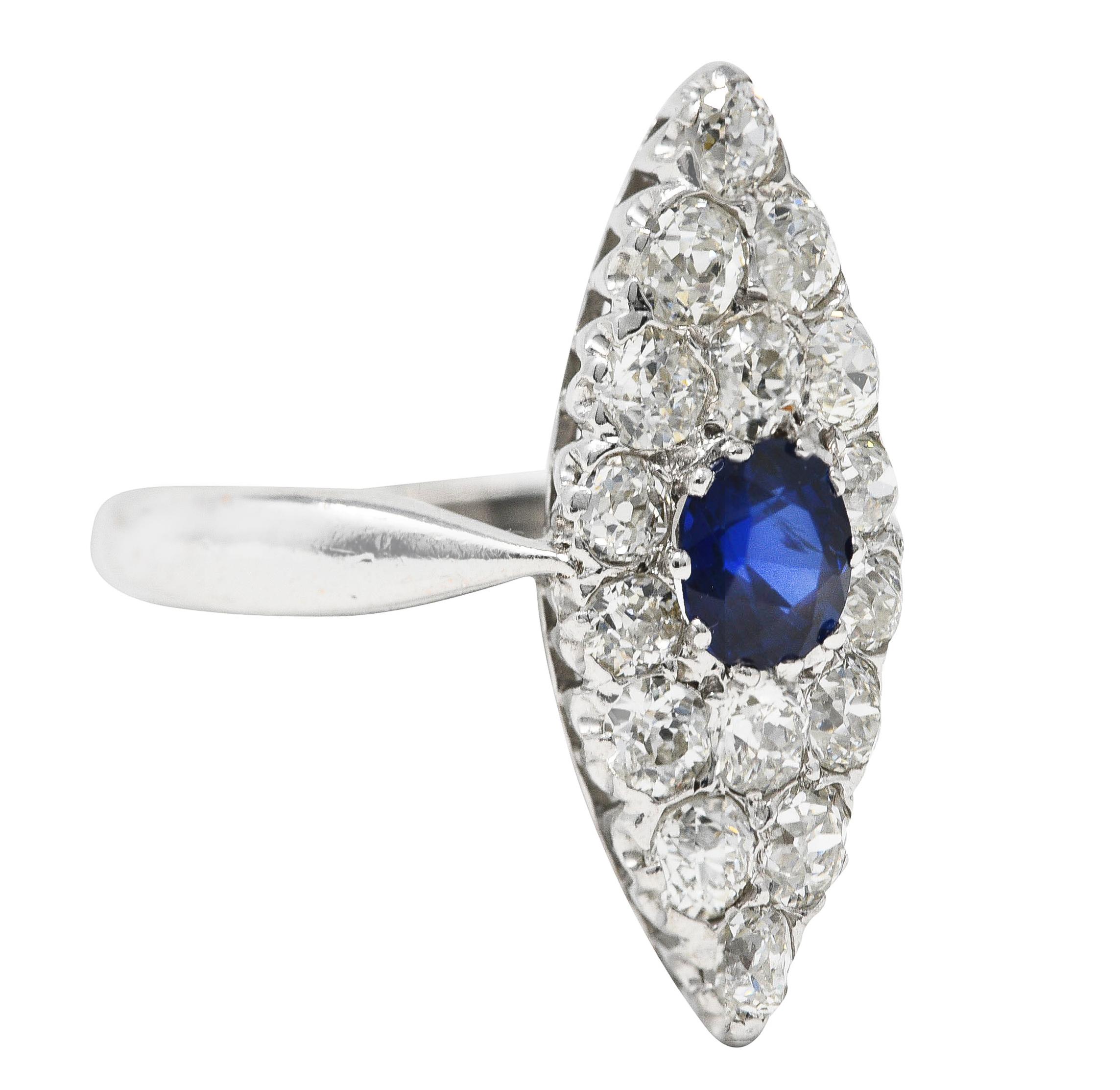 Centering a cushion cut sapphire weighing approximately 0.60 carat total - transparent medium ultramarine blue. Prong set in a navette shaped surround with old mine cut diamonds pavé set throughout. Weighing approximately 0.96 carat total - H/I