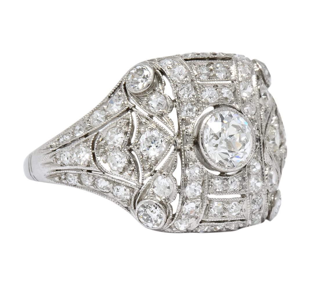 Designed as a square form with millegrain edges centering a bezel set old European cut diamond weighing approximately 0.40 carat, I color and SI1 clarity

Surrounded by pierced design and shoulders with scallop and tulip motif

Set throughout with