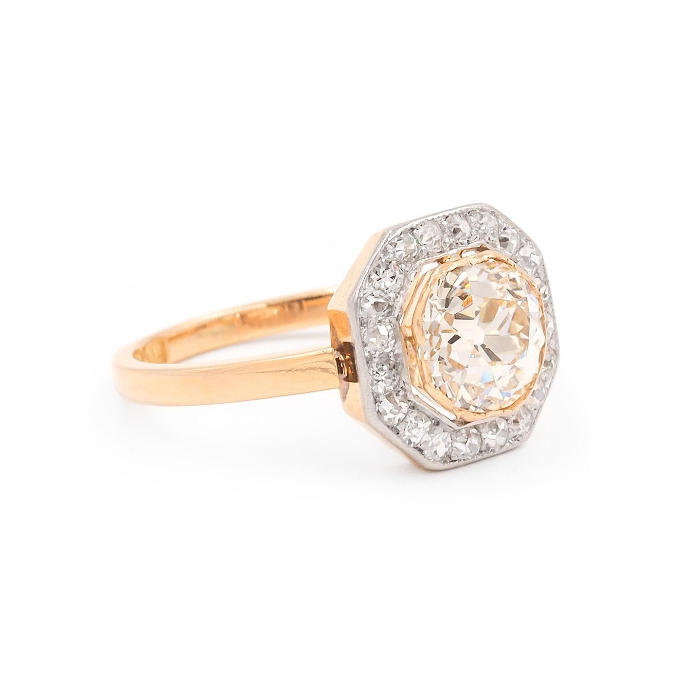 Edwardian era 1.70 Carat Old European Cut Diamond Cluster Engagement Ring composed of 18k yellow gold and platinum. With a 1.70 Carat Old European Cut diamond, GIA certified N color & SI1 clarity. The center diamond is set in an 18k gold octagonal