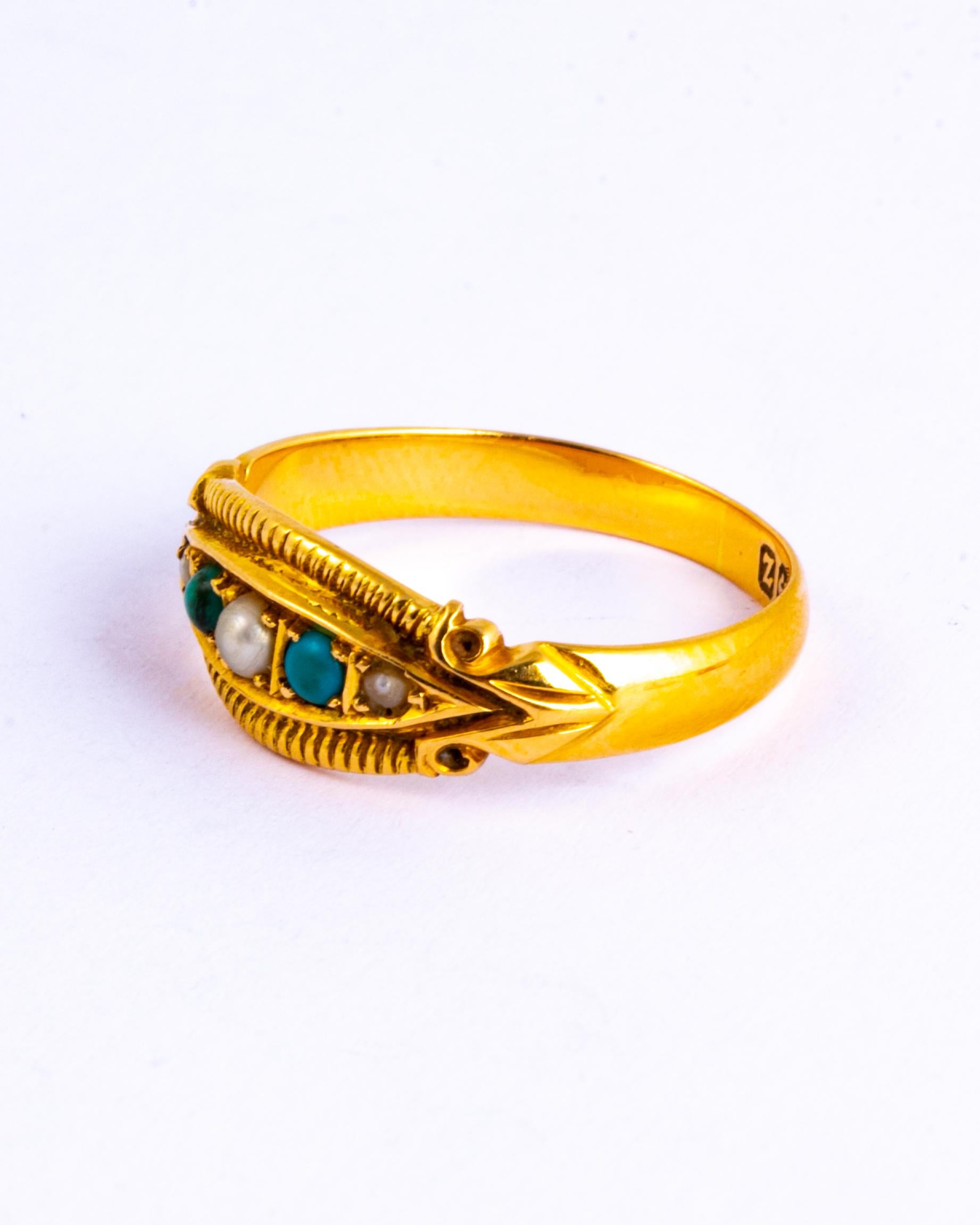 This ring holds two turquoise stones and three pearls. The stones are set in a boat shape setting which has heavily engraved detail around the frame and scrolled shoulders. Modelled in 18 carat yellow gold and made in Birmingham, England.

Ring