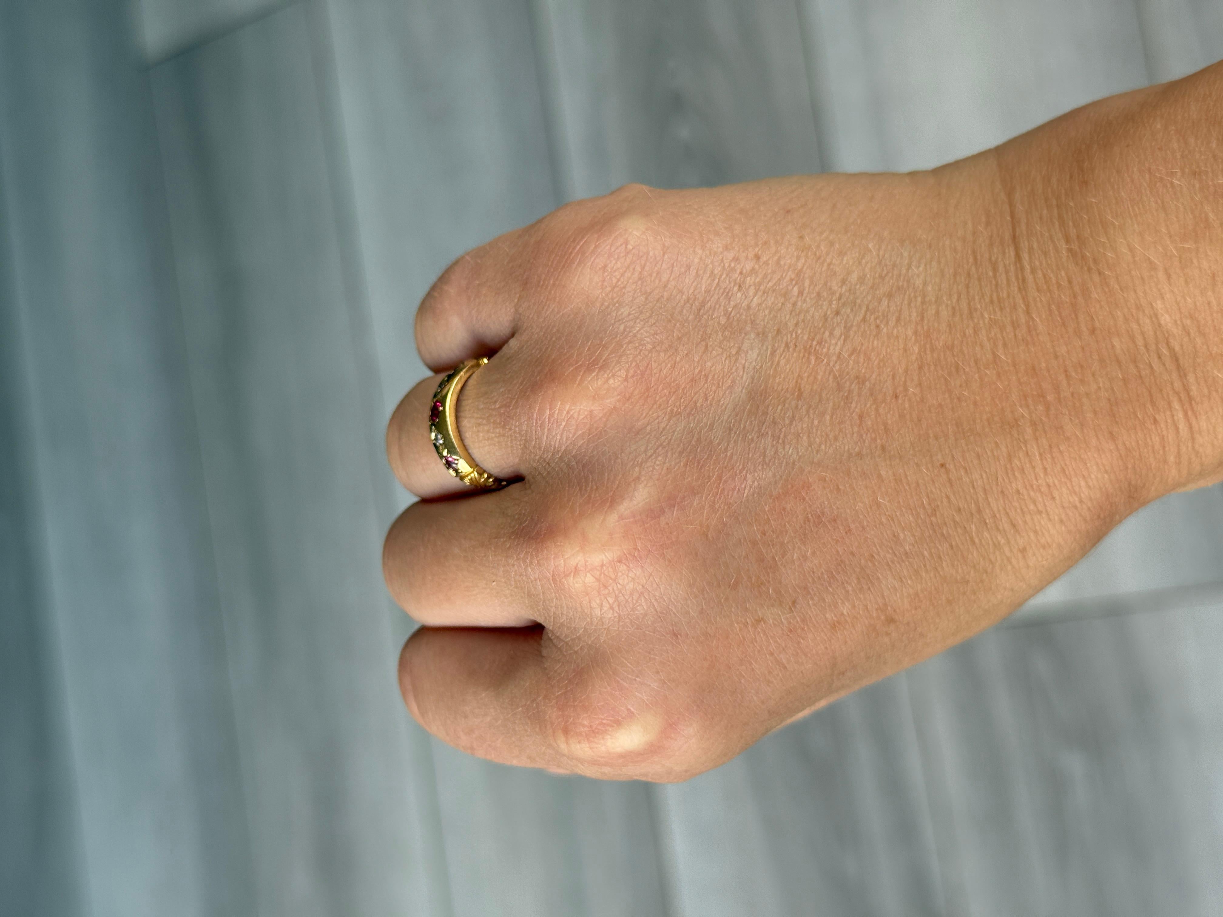 Este anillo edwardain está engastado con dos diamantes y tres rubíes. Los diamantes miden aproximadamente 4 puntos cada uno. El rubí central mide 10 puntos y los más pequeños miden 5 puntos cada uno. Modelado en oro amarillo de 18 quilates.