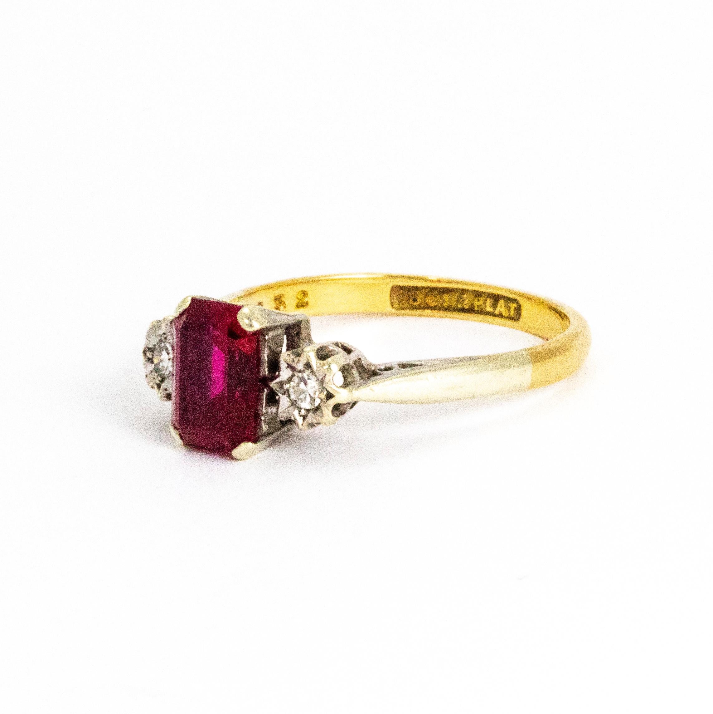 A stunning antique Edwardian three-stone ring. The central emerald cut ruby measures approximately 1 carat and has fantastic colour, flanked either side by fantastic white diamonds in star settings. The stones are set in platinum and the band is