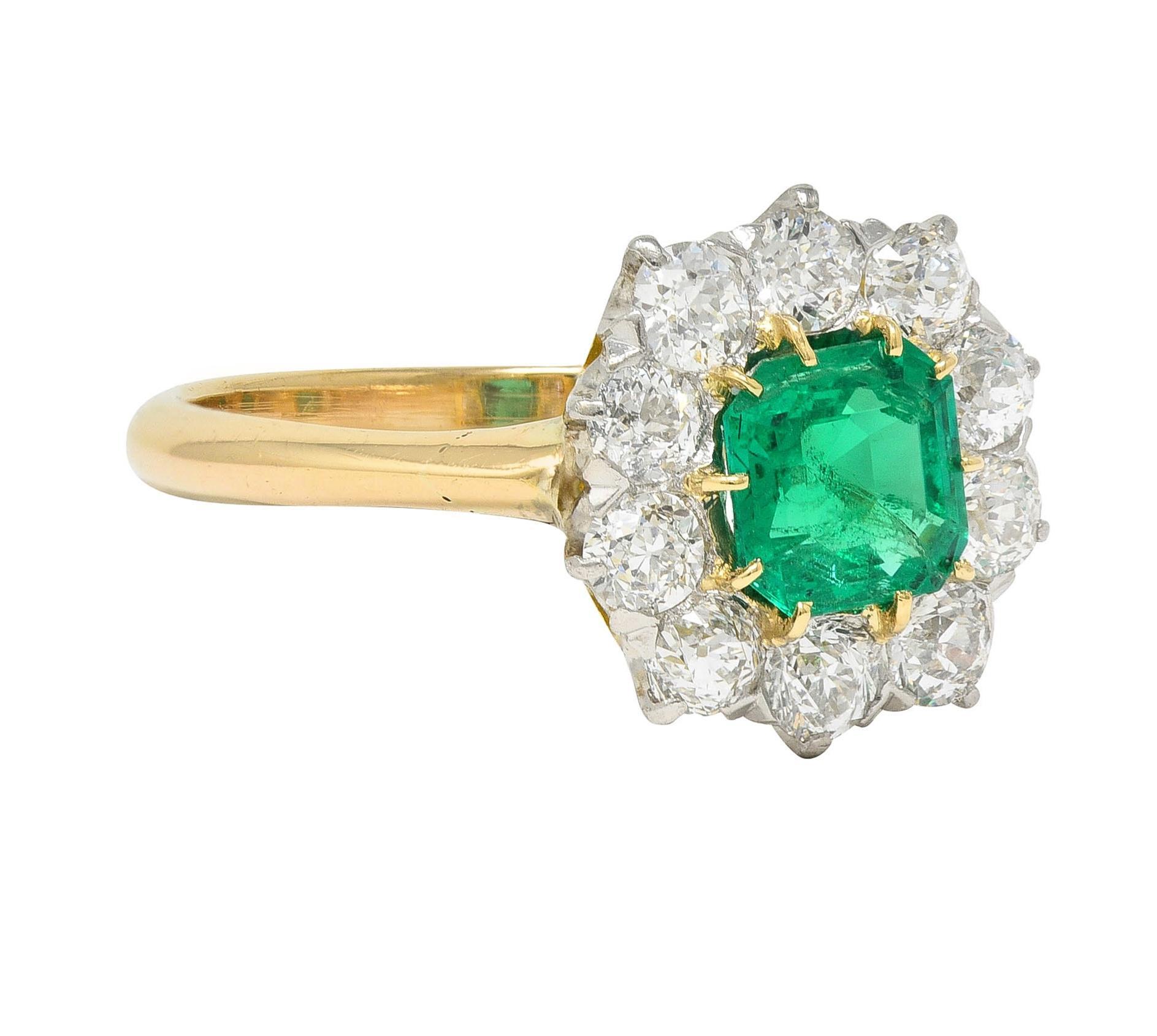 Centering an emerald cut emerald weighing approximately 0.80 carat - transparent medium green 
Set with gold talon prongs with a recessed platinum halo surround of old European cut diamonds
Weighing approximately 1.00 carats total - G/H color with