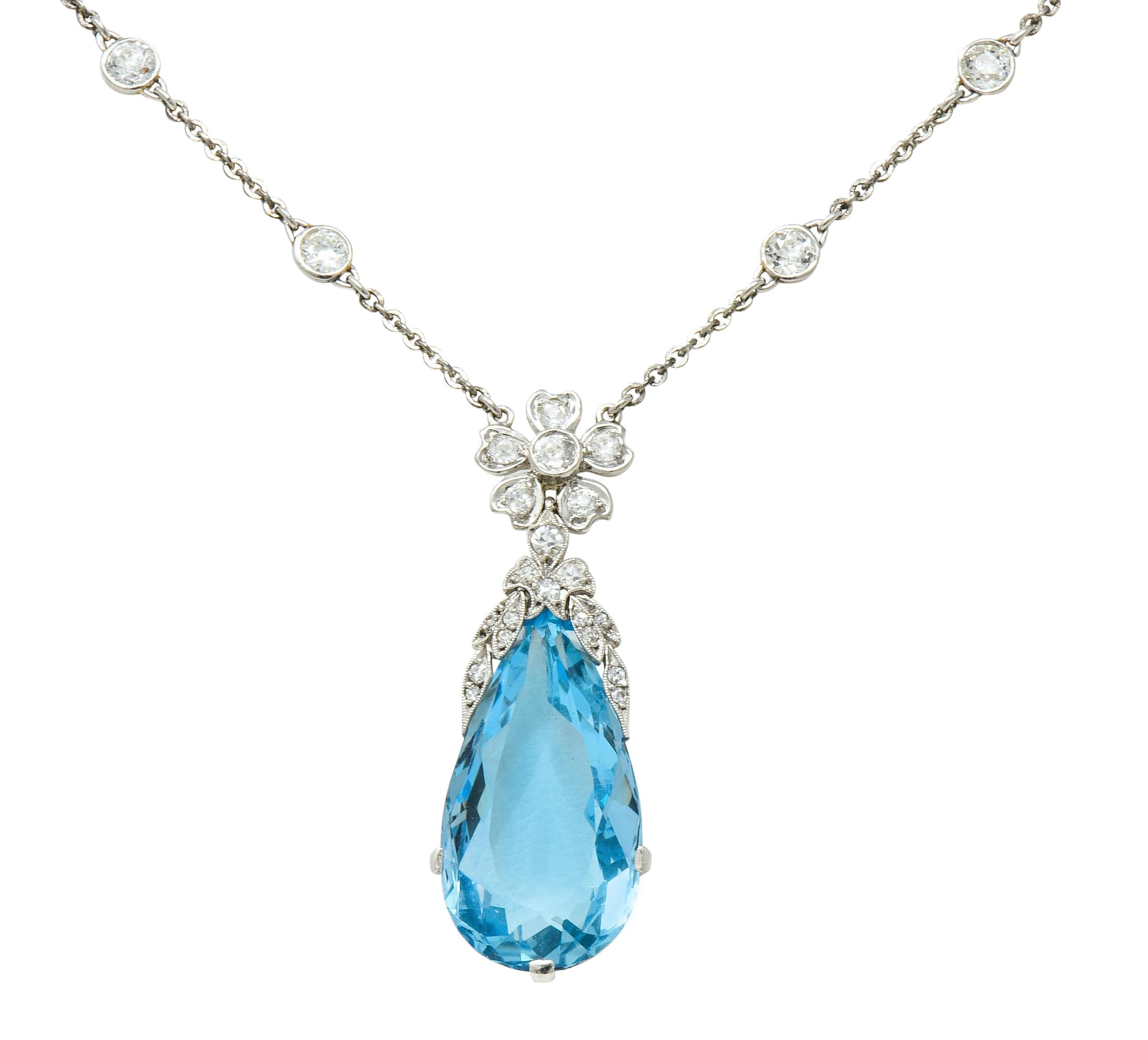 Centering a basket set pear cut aquamarine drop weighing approximately 16.73 carats, transparent and a bright sky blue color

Topped by a foliate and floral motif decorated by milgrain and set throughout by single cut and old European cut diamonds