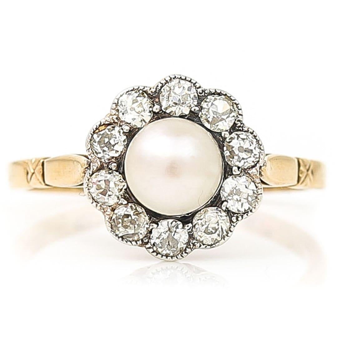 A beautiful Edwardian pearl and diamond cluster ring set ten old brilliant-cut diamonds and dating from circa 1900. The old cut diamonds of approx 0.50ct are set around a luscious pearl, of creamy silver lustre all set in silver. Such a pretty