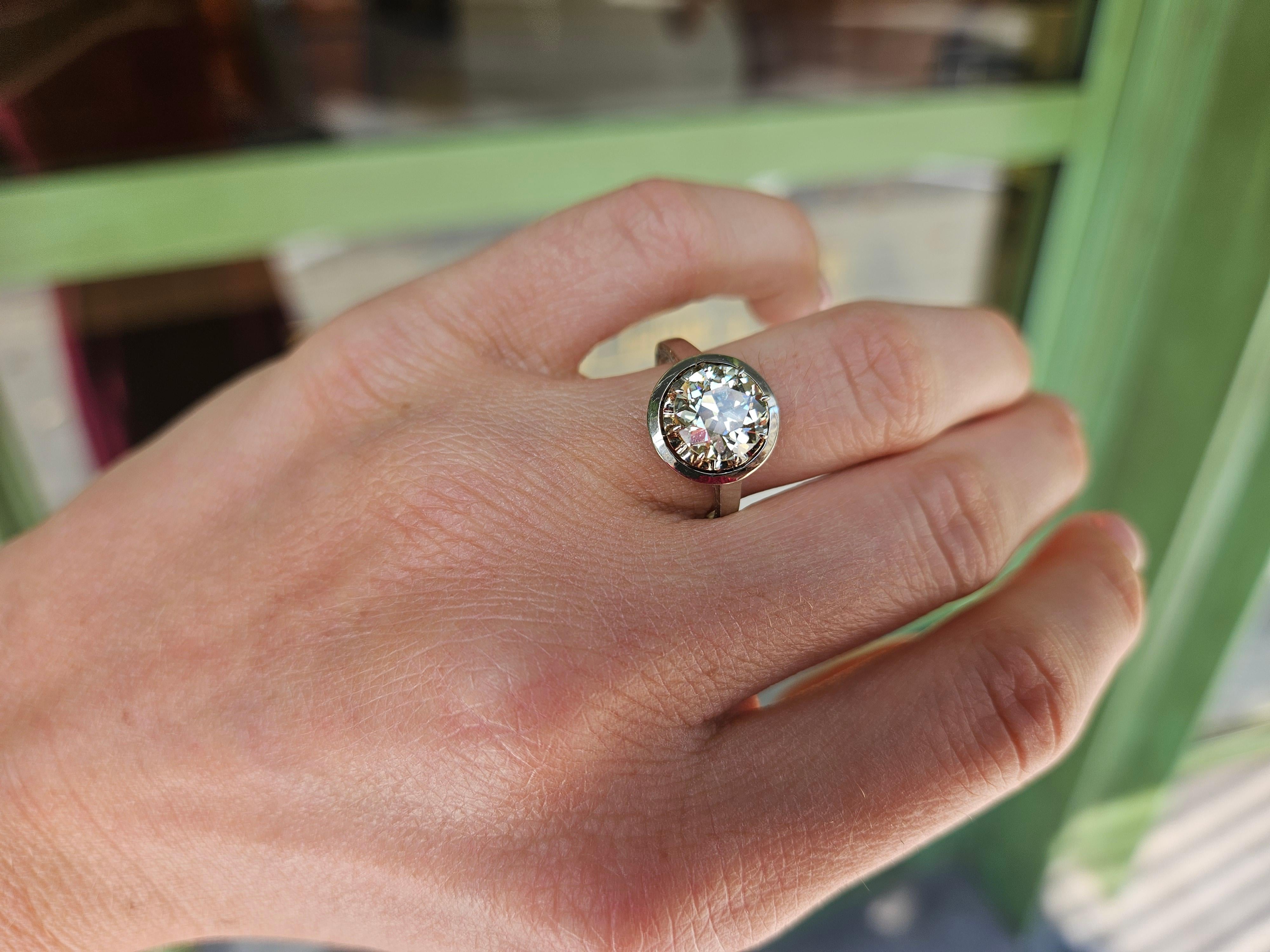 Cette bague est ornée d'un diamant de taille ancienne d'environ 2,1cts (8,4 mm x 8,2 mm x 5 mm), de couleur M et de pureté VS2-Si1. La vidéo a été tournée en lumière naturelle, sans aucun montage ni filtre. Sur demande, je peux faire certifier la