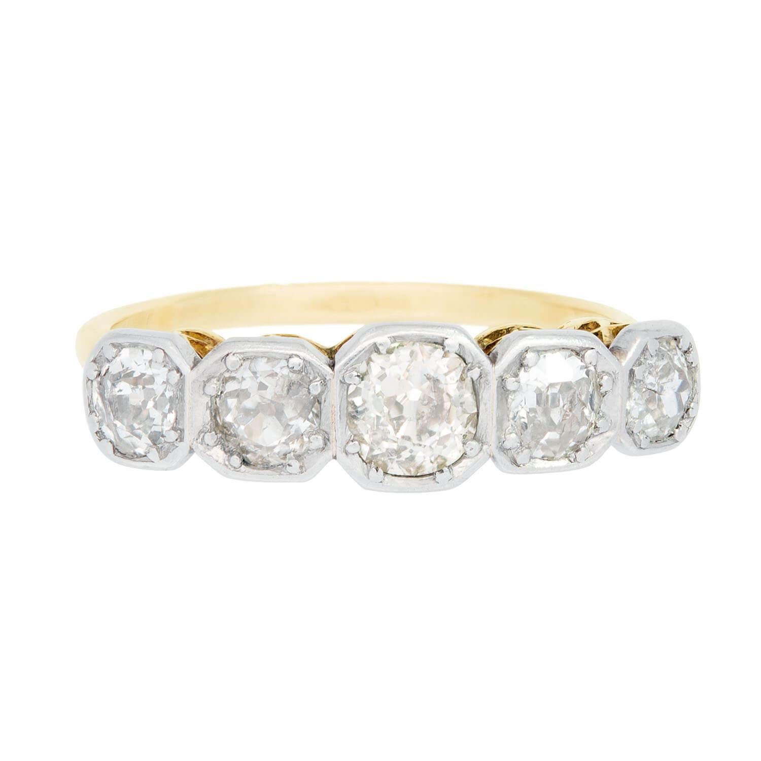 A gorgeous diamond ring from the Edwardian (ca1910)! Crafted in 18k yellow gold and platinum, this ring features five old mine cut diamonds running horizontally across the front of the piece. The diamonds graduate slightly in size, and are held in