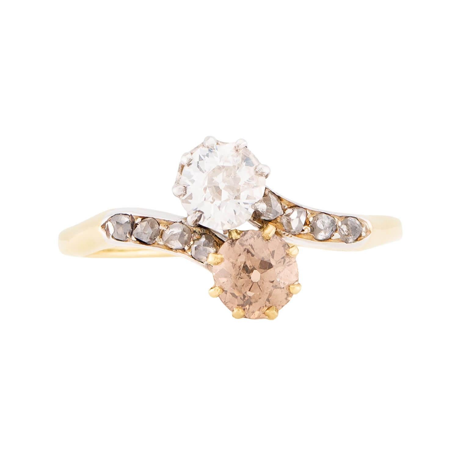 A breathtaking diamond bypass ring from the Edwardian (ca1910s) era! Crafted in 18k yellow gold, this lovely piece features two old mine cut diamonds nestled together at the center, forming a stylish 