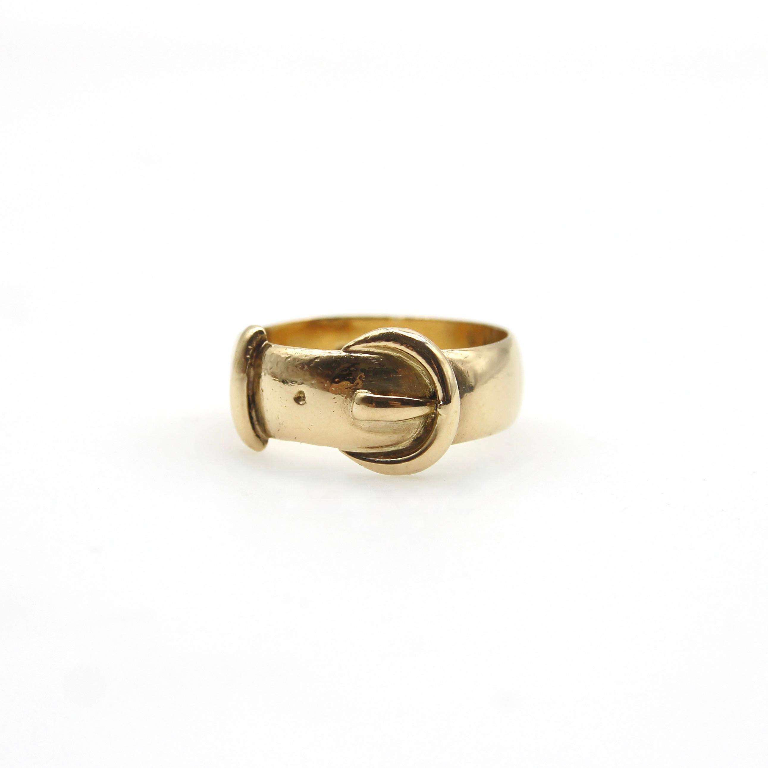 Made in England in 1919, this 18k gold buckle ring is an Edwardian take on the Victorian symbol for everlasting love. The ring has a curvilinear nature, with a rounded crescent moon shaped buckle and curved strap. The wide band and subtle design