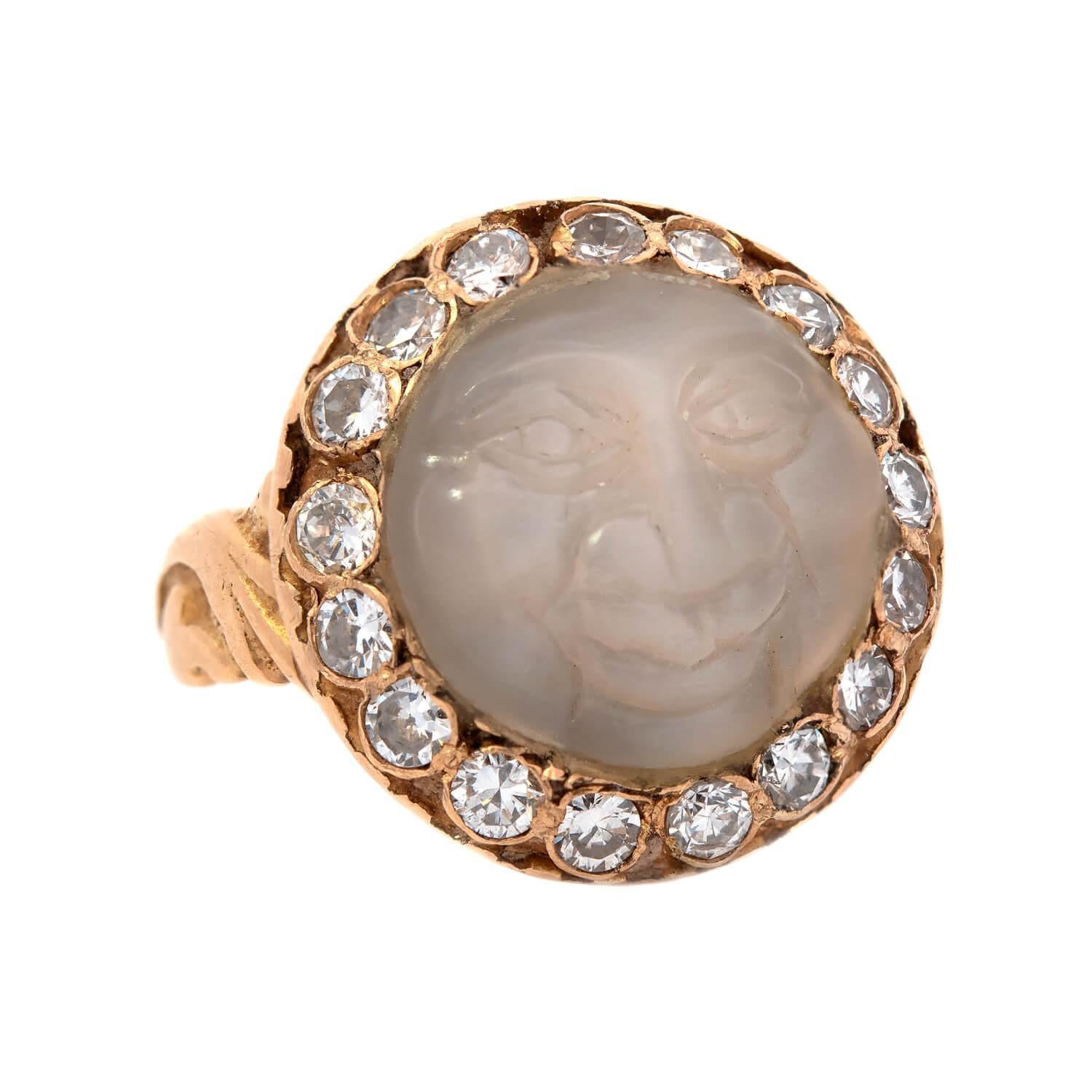 A fabulous Man in the Moon ring from the Edwardian (ca1910s) era! Handcrafted in vibrant 18kt yellow gold, this handsome carved moonstone man smiles with detailed facial features, encircled by 17 glittering Old Mine Cut diamonds. Each diamond is