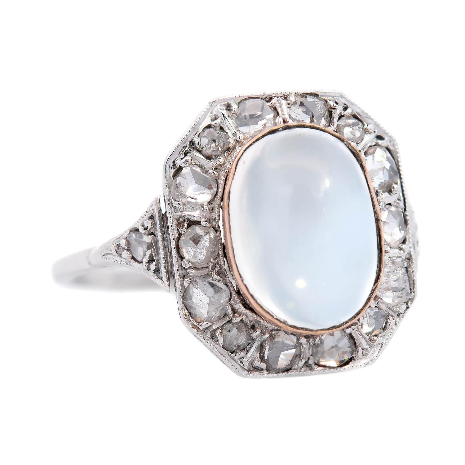 An exquisite moonstone and diamond ring from the Edwardian (ca1910) era! Crafted in  18k white gold with a yellow gold bezel, the silvery-grey moonstone cabochon is surrounded by a halo of 10 old rose cut diamonds, each one bead set in white gold