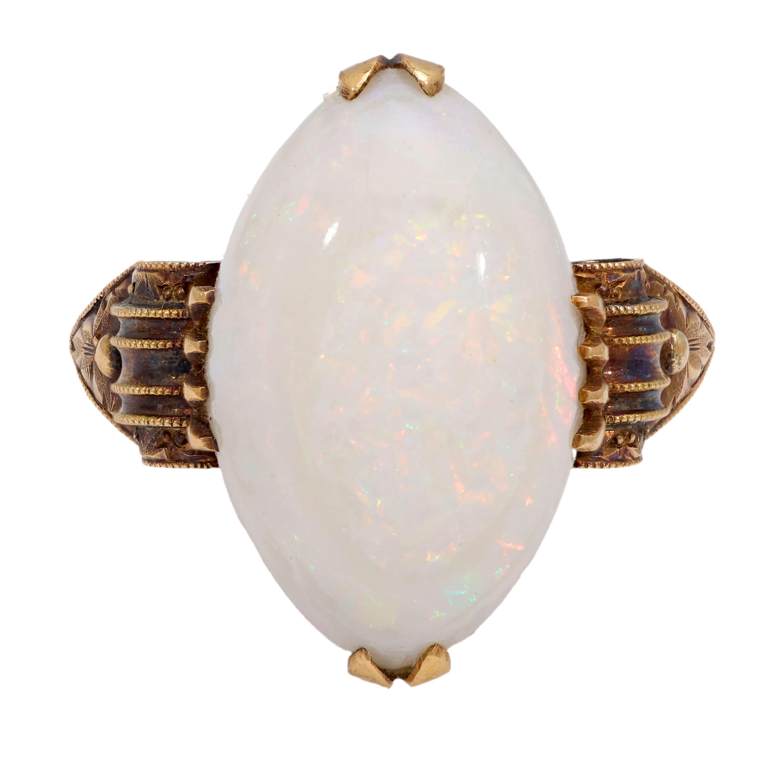 Questo anello di opale di epoca edoardiana (ca. 1910) è un accessorio molto elegante! Realizzato in oro 18 carati, questo anello presenta un opale cabochon da 8 carati racchiuso in una montatura a quattro punte. L'opale mostra deliziosi lampi di