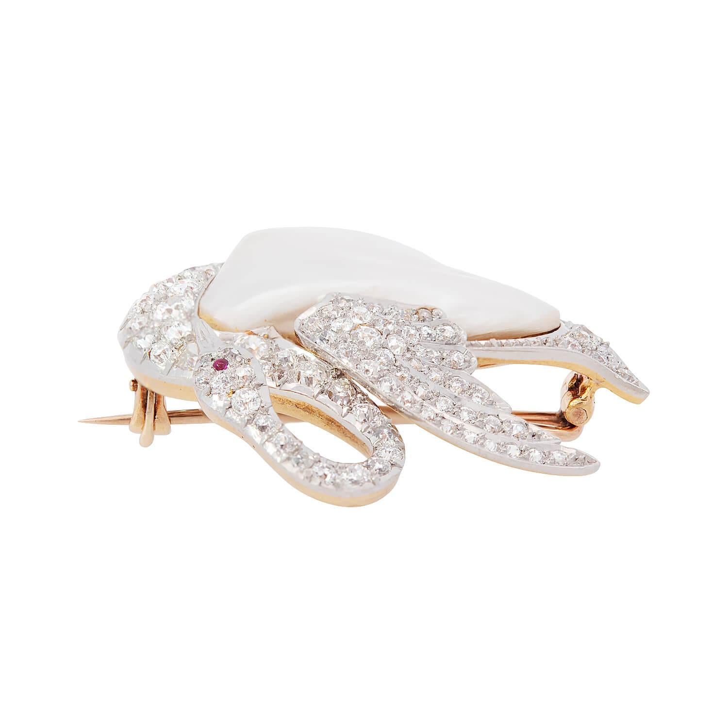 A wonderful diamond, pearl, and ruby swan pin from the Edwardian (ca1910s) era! This lovely piece is crafted in 18k yellow gold and platinum, and depicts a romantic swan. The torso of the swan features a uniquely-shaped bezel set pearl. The graceful