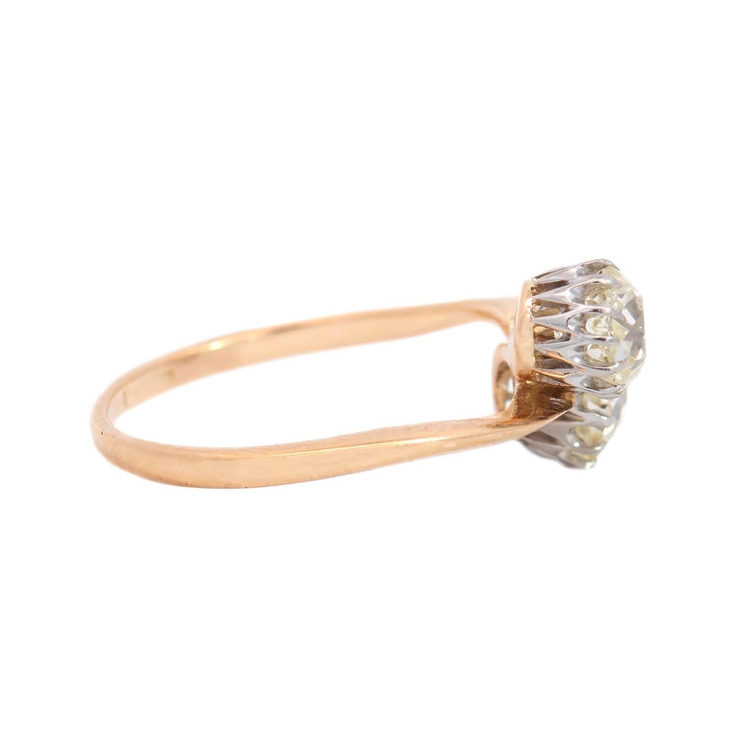 A unique and exquisite diamond bypass ring from the Edwardian (ca1910) era! Crafted in 18k yellow gold with platinum prongs, this piece features two old Mine Cut diamonds nestled together at the center, forming a stylish 