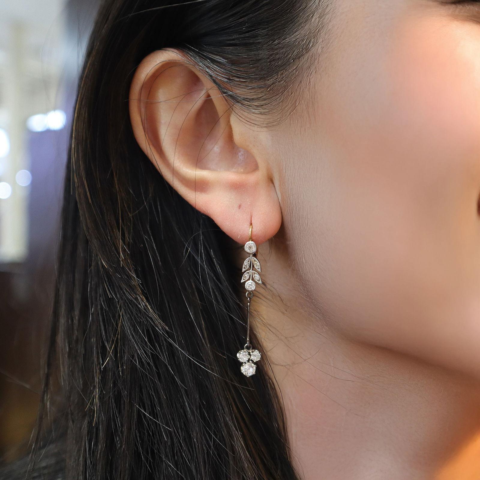 Dieses raffinierte Paar edwardianischer Ohrringe ist aus 18-karätigem Gelbgold mit Platinakzenten gefertigt und fängt die feine Raffinesse des Designs des frühen 20. Jeder Ohrring besteht aus einer Kombination von 10 natürlichen Diamanten im