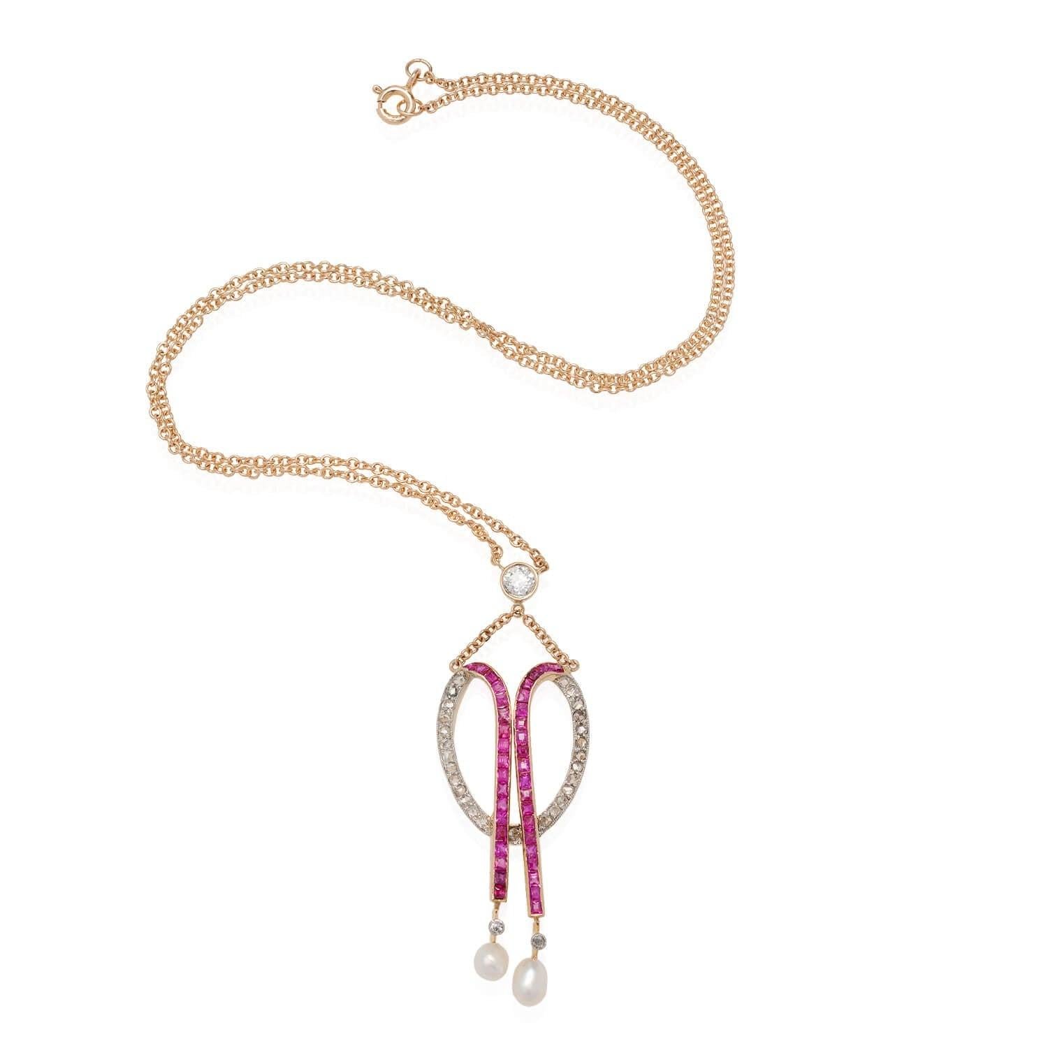 A gorgeous pendant necklace from the Edwardian (ca1910s) era! Crafted in 18kt yellow gold and topped in platinum, this unique pendant has an elegant design of glittering Single Cut diamonds and Square Cut calibrated rubies. The bead-set diamonds,