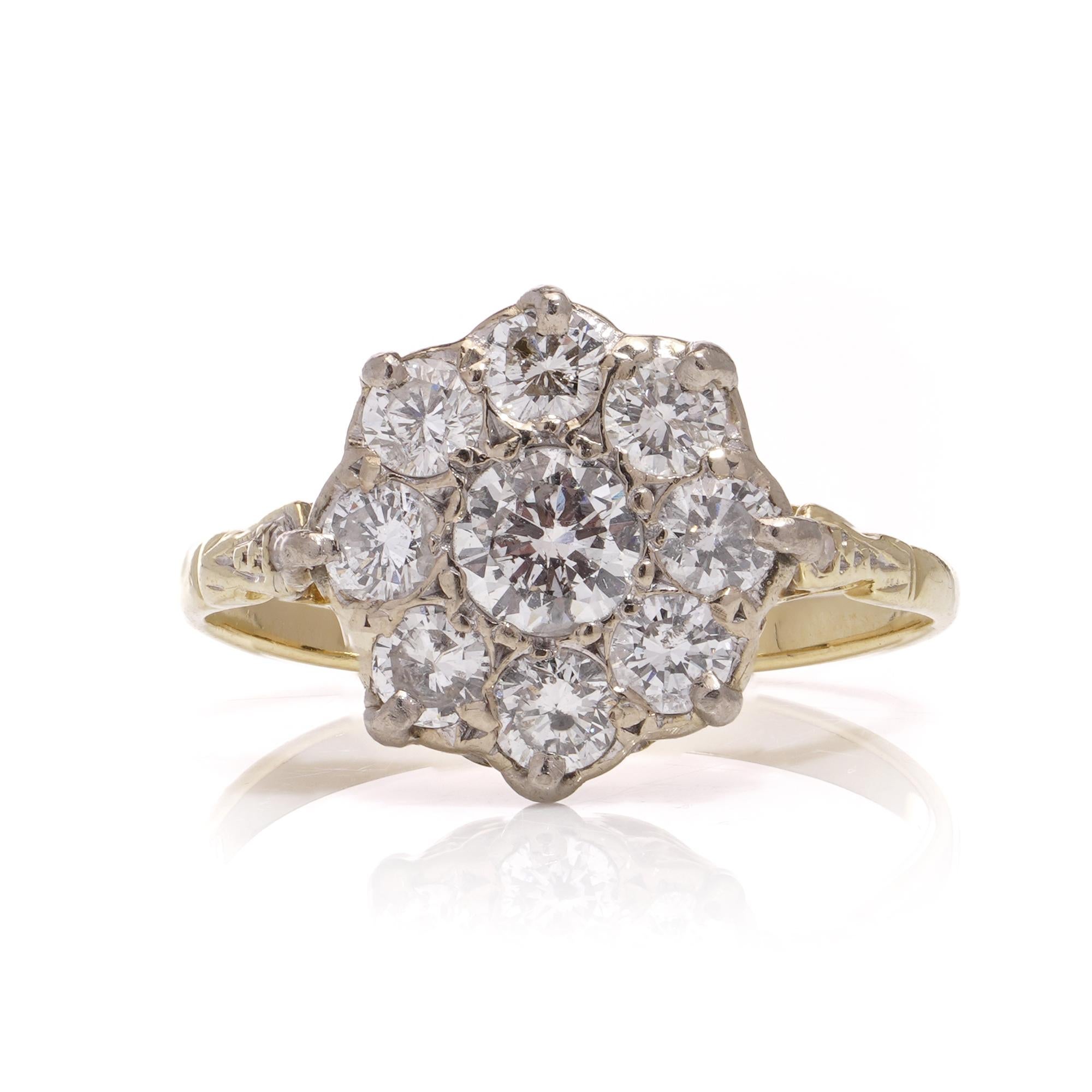 This exquisite Edwardian ring boasts an 18kt yellow gold daisy flower design, adorned with dazzling diamonds. At its heart, a brilliant round cut diamond shines, encircled by eight smaller diamonds. The band is elegantly accented with two additional