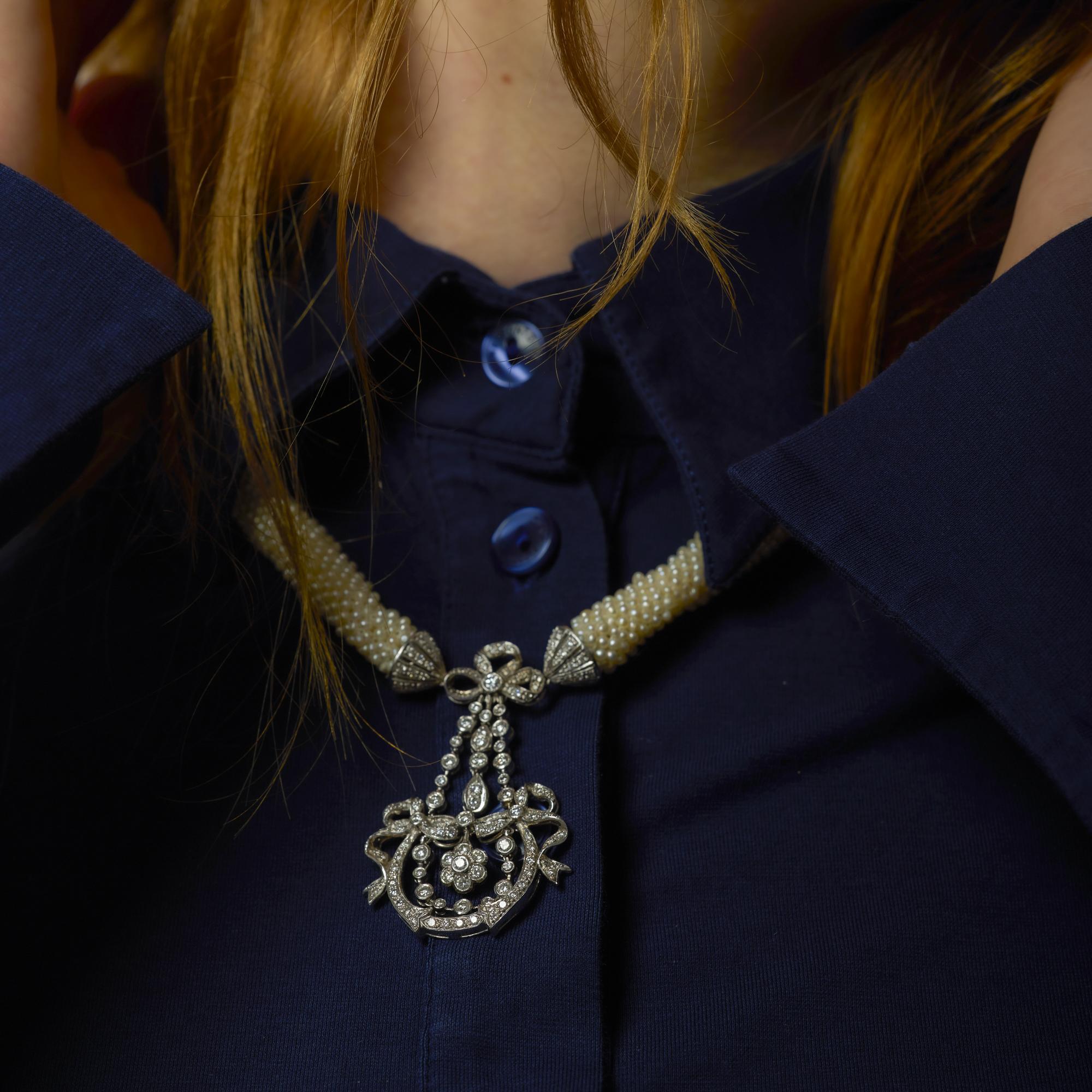 Un lujoso collar eduardiano de platino adornado con luminosas perlas en bruto y un deslumbrante conjunto de brillantes diamantes en un delicado y romántico diseño antiguo.