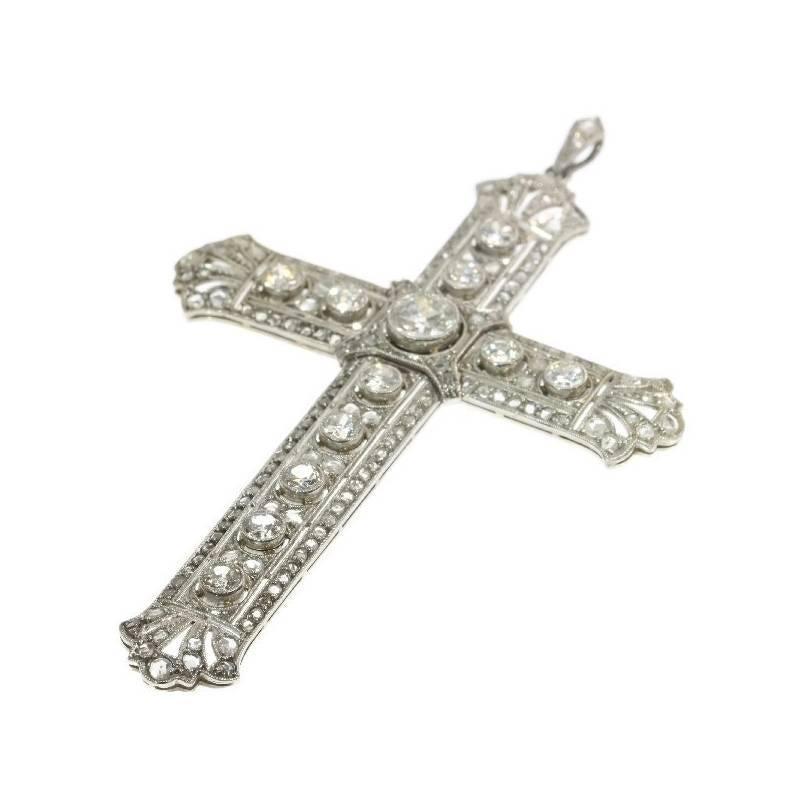 An Edwardian cross pendant in platinum and 18 karat white gold set with a center old European cut diamond .60 carat (color and clarity grade: H/I, i/), 9 old European cut diamonds totaling 1.30 carat (color and clarity grade: H/I, vs/i) and 144 rose