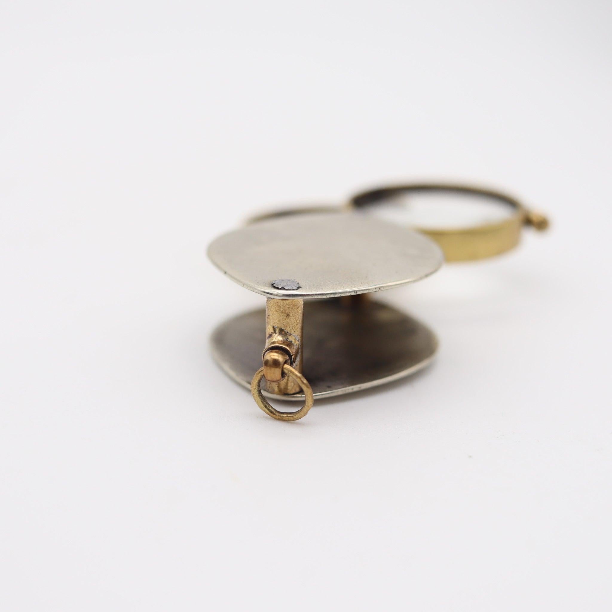 Pendentif britannique à double loupes de la période édouardienne.

Il s'agit d'un magnifique pendentif continental à double loupes pliantes créé en Angleterre pendant la période édouardienne, dans les années 1905. La loupe a été fabriquée en bronze
