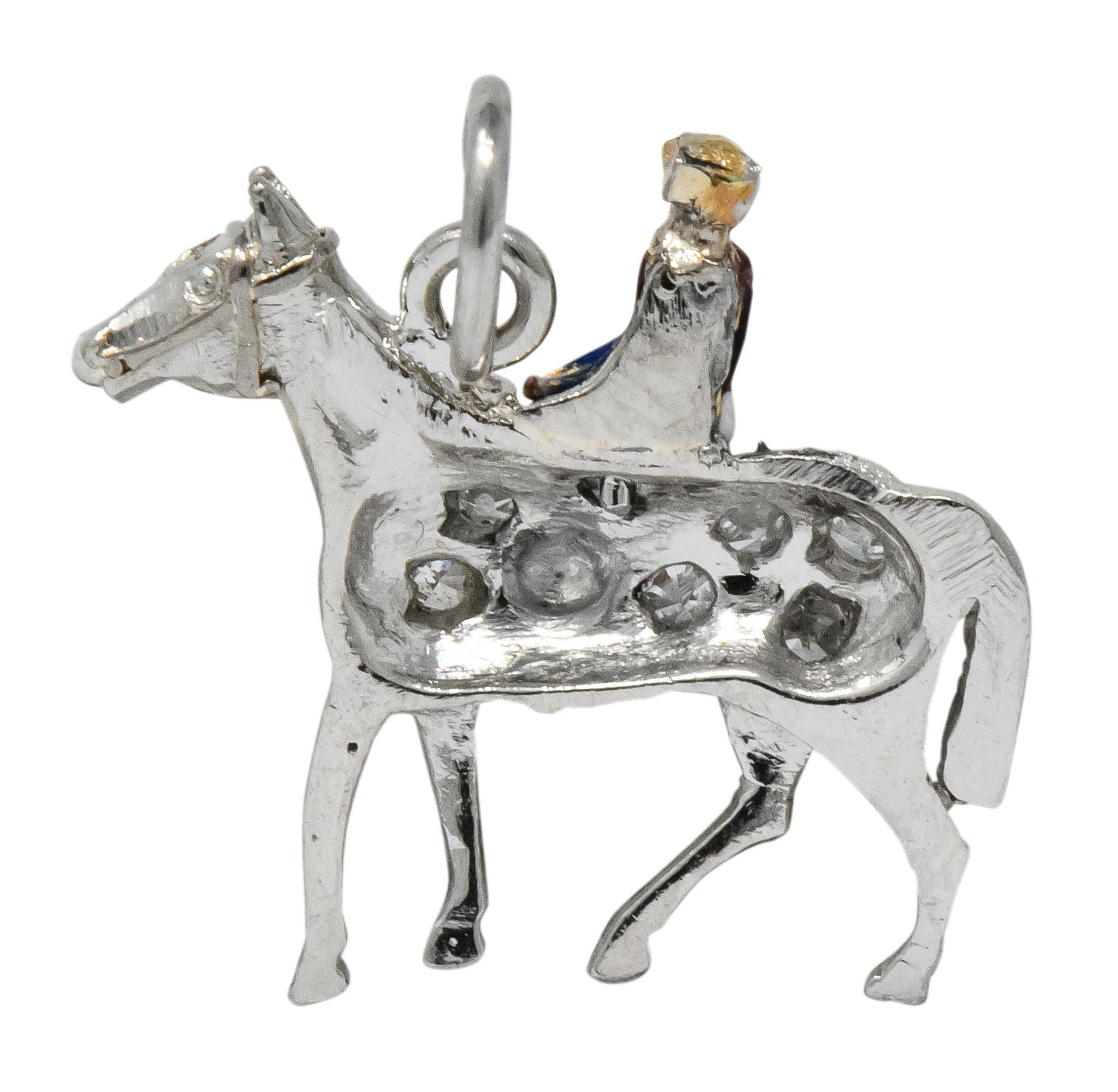 Charm is designed as colorful jockey riding a pavé set platinum horse

Jockey features red, white, and blue enamel with gold details; features some loss consistent to age, wear, and use

Trotting horse is set throughout with rose cut and single cut
