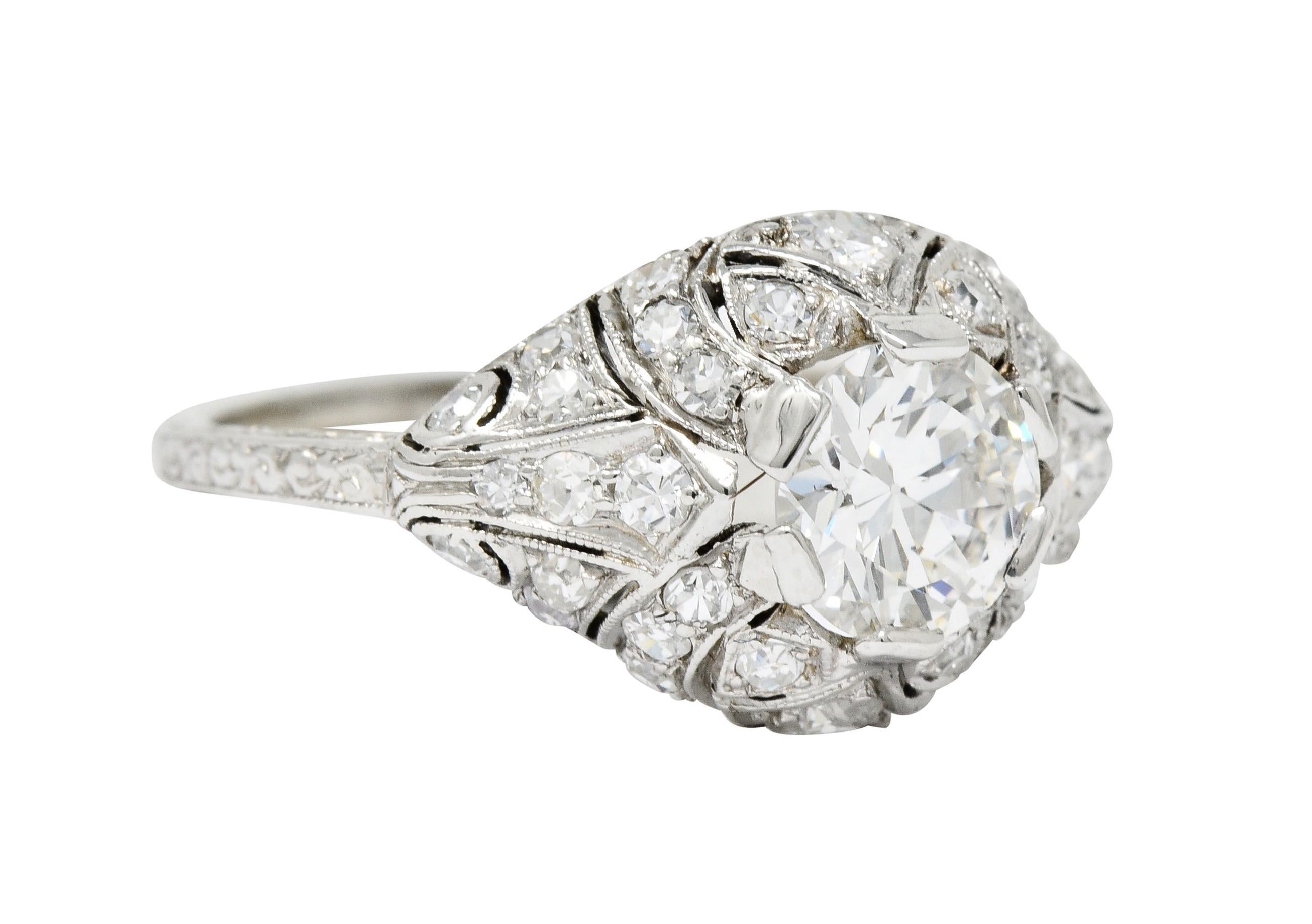 Centering a transitional cut diamond weighing 1.15 carat; H color with SI1 clarity

Set low in pierced bombé mounting with milgrain detail and scrolled engraving

Accented throughout by round brilliant, single, and old European cut