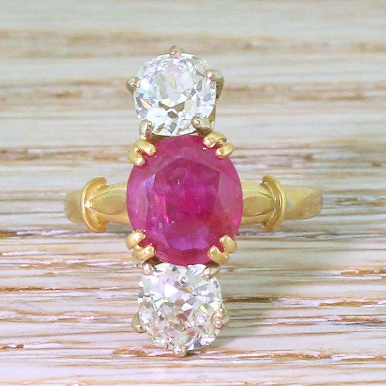 Utterly magnificent. The natural, unheated ruby in the centre displays a bright pinkish red, set in four yellow gold split claws and is accented at the top and bottom by a pair of white and lively old mine cut diamonds, in platinum. Marquise shaped