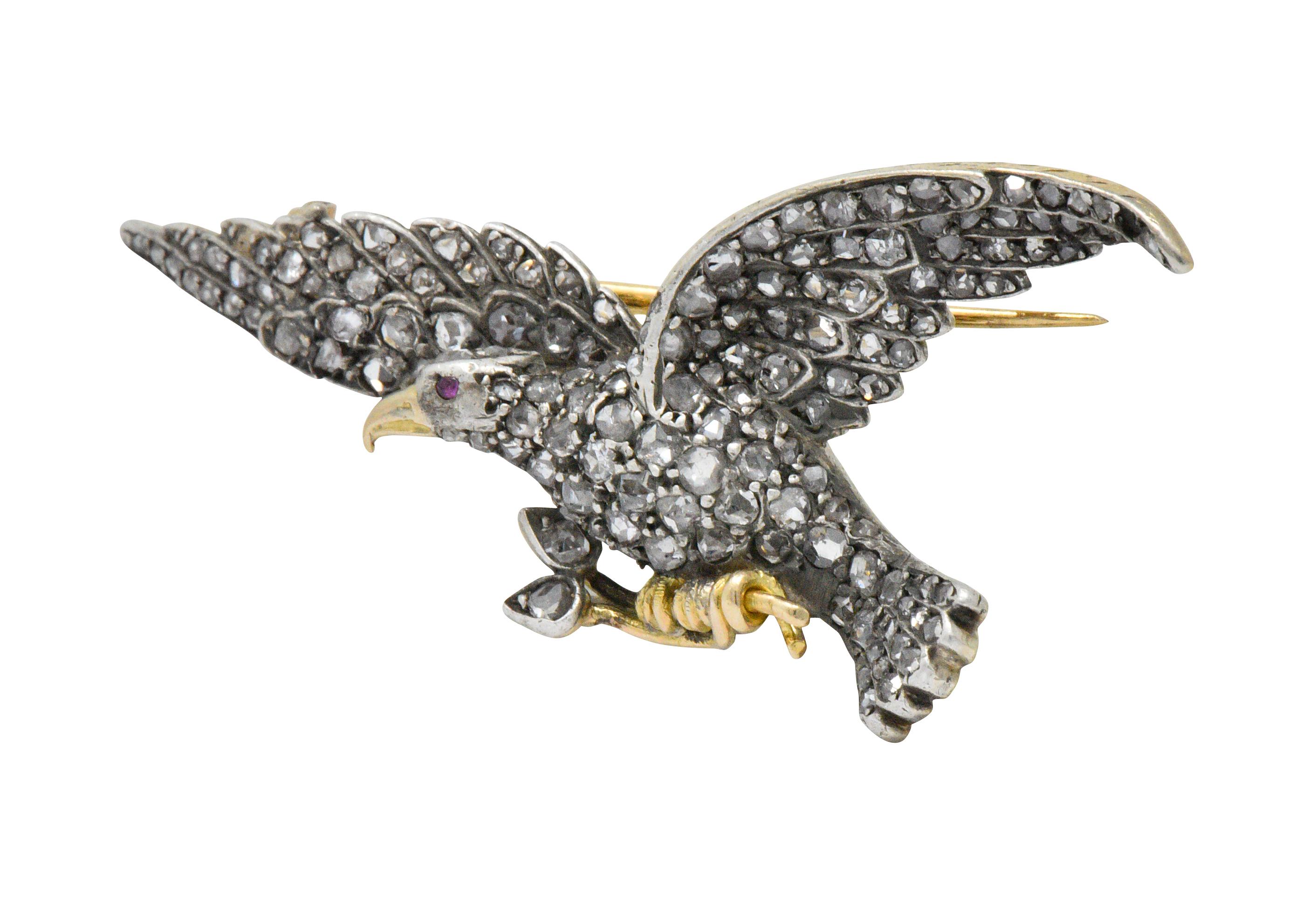Featuring an eagle in mid-flight clutching flowers in his talons

Set throughout with rose cut diamonds weighing approximately 2.00 carats, G to J color and VS to I clarity and a ruby eye

Bright yellow gold beak and talons create striking