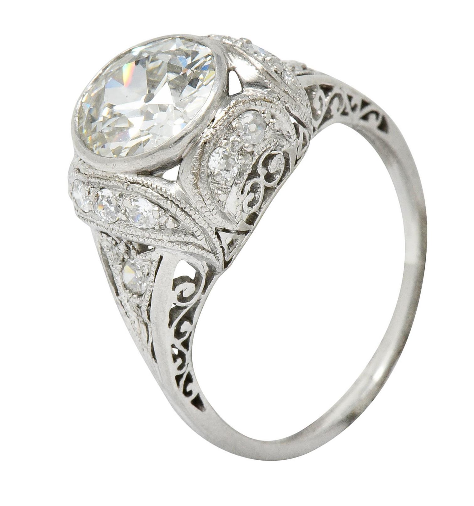 Centering a bezel set old European cut diamond weighing 1.73 carats; K color with SI1 clarity
With a cushioned surround, filigree gallery, and pointed shoulders

Accented by old European cut diamonds weighing approximately 0.32 carats; eye-clean and