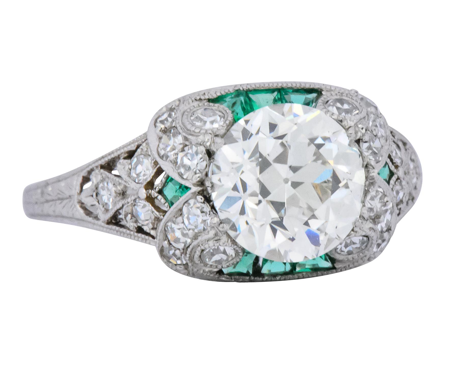 Centering an old European cut diamond weighing 1.59 carats, J color and SI1 clarity

With vibrant calibré french cut emeralds, channel set, tucked under the center

Accented by single cut diamonds weighing approximately 0.51 carats total, H color