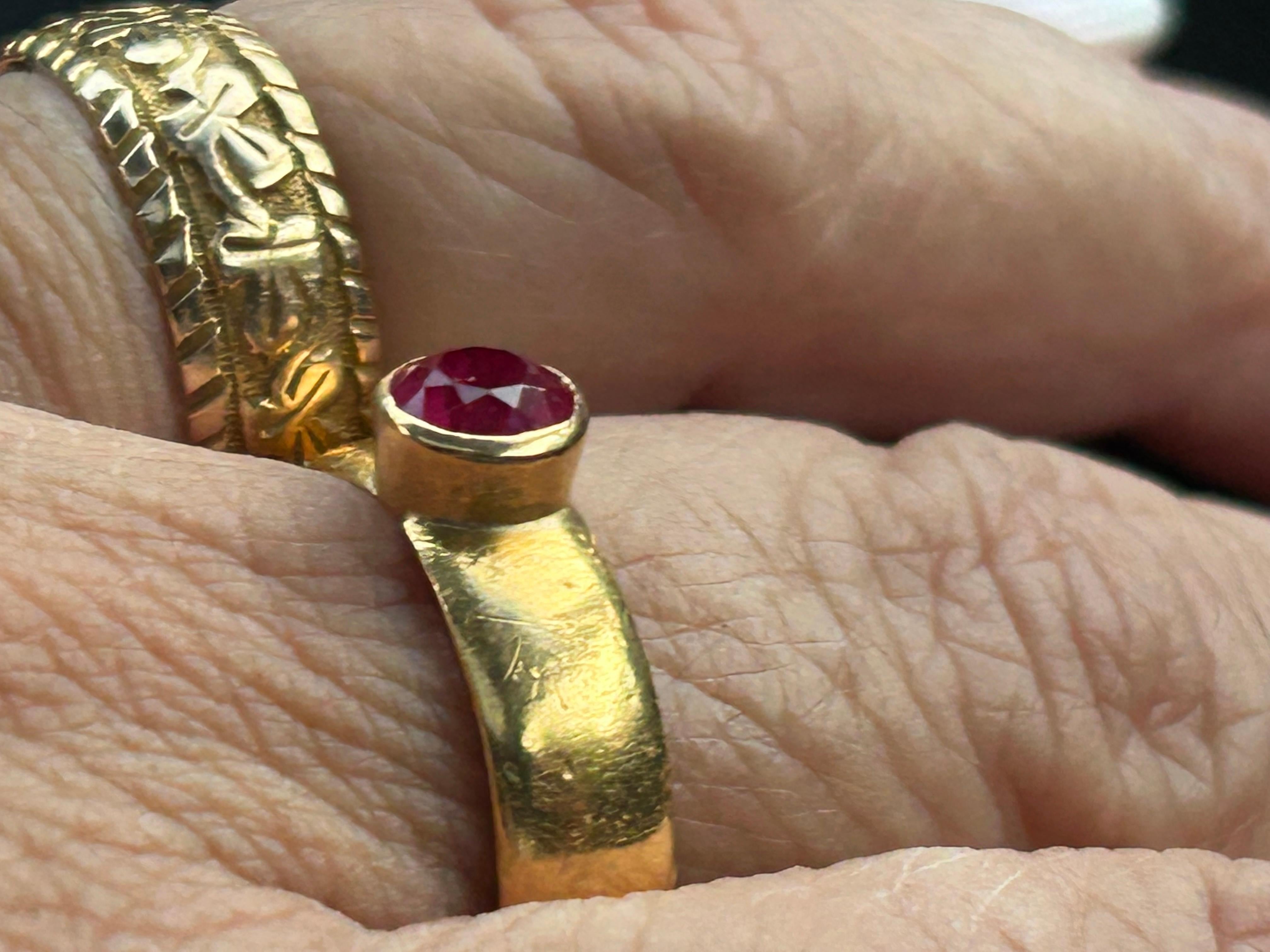 Timeless elegance with our exquisite Edwardian 22-karat buttery, old gold ring, featuring a mesmerizing round faceted synthetic ruby. This remarkable piece, crafted in 1916 by the renowned jeweler Harry Atkins in Birmingham, England, is a true