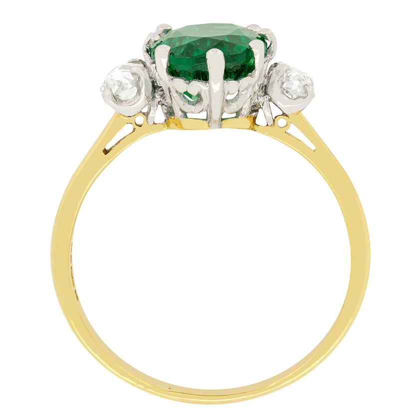 An infatuating 2.35ct natural emerald sits between two 0.20 carat old cut diamonds. The diamonds have been estimated as G in colour and VS in clarity. The oval shaped emerald along with the diamonds, are set within sturdy platinum claws. In line