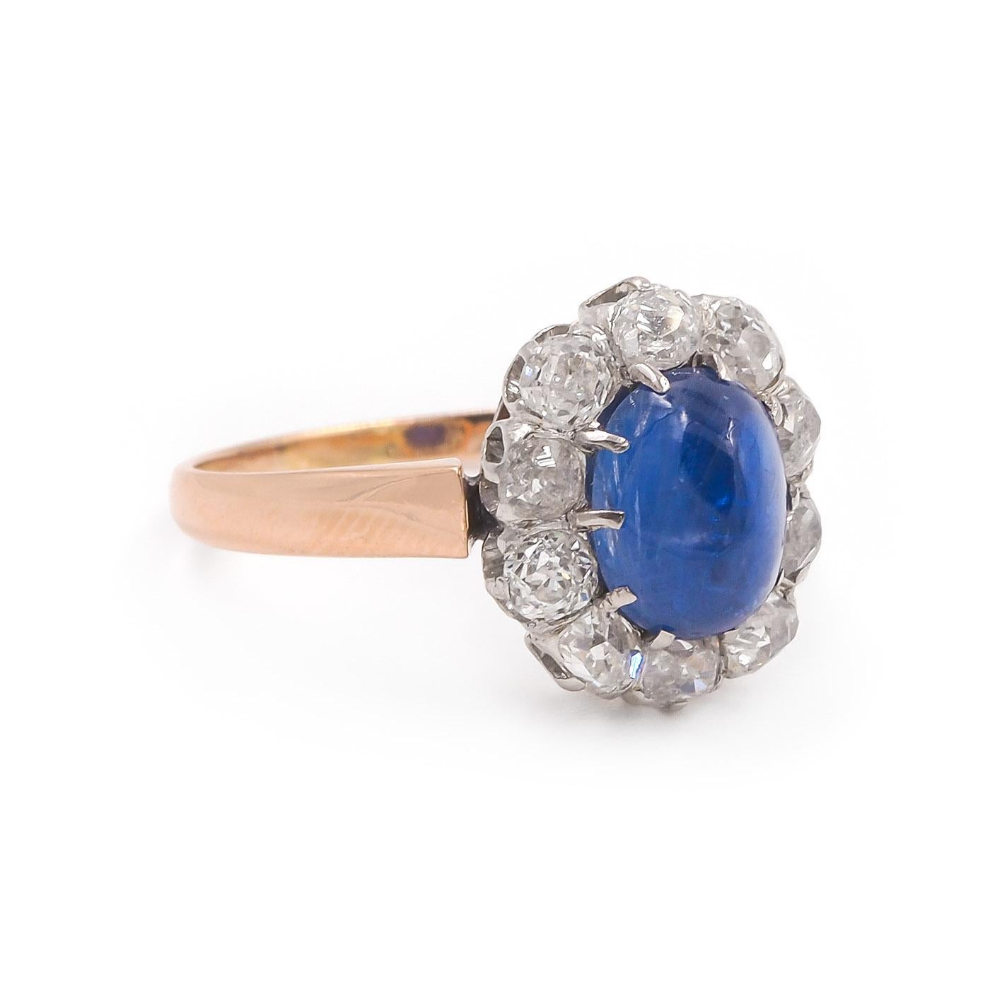 Edwardian era French import 2.40 Carat Oval Cabochon Sapphire & Old Mine Cut Diamond Cluster Engagement Ring, composed of 18k rose gold & platinum. The 2.40 carat Oval Cabochon blue sapphire is AGL certified, from Burma and is Unheated. With an