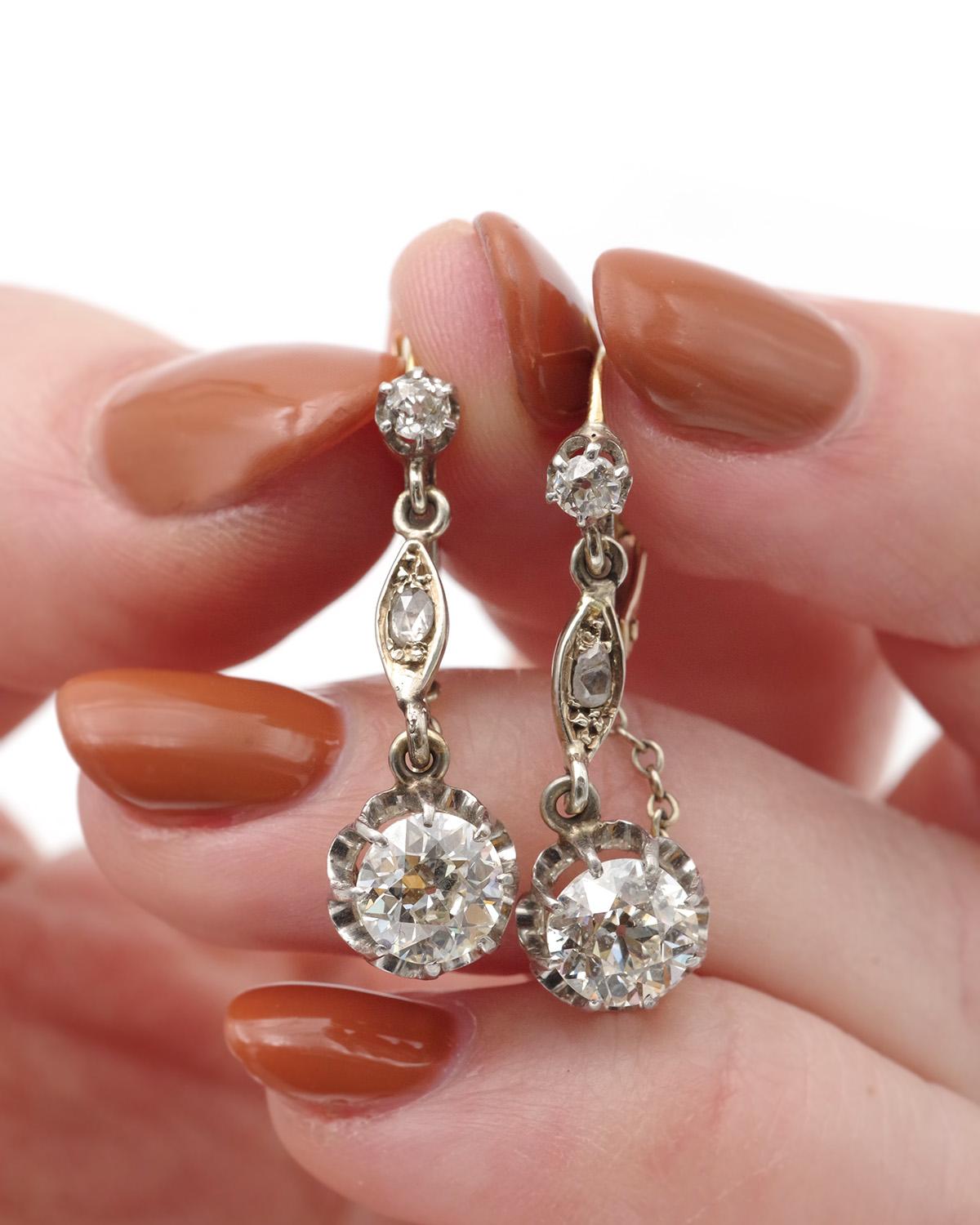 Longues boucles d'oreilles en diamant 2,46 cts en or 18 carats et platine. Les diamants principaux pèsent respectivement 1,18 carat et 1,04 carat et sont de taille ancienne. Les boucles d'oreilles sont également serties d'un diamant de taille