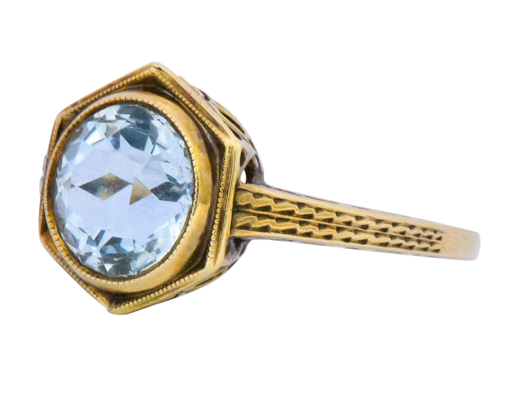Centering an old European cut aquamarine weighing approximately 2.50 carats, beautiful light blue

Bezel set in a hexagonal surround

Pierced and engraved gold gallery and shank

Stamped 14K with maker's mark

Ring Size: 5 1/2 & Sizable

Top