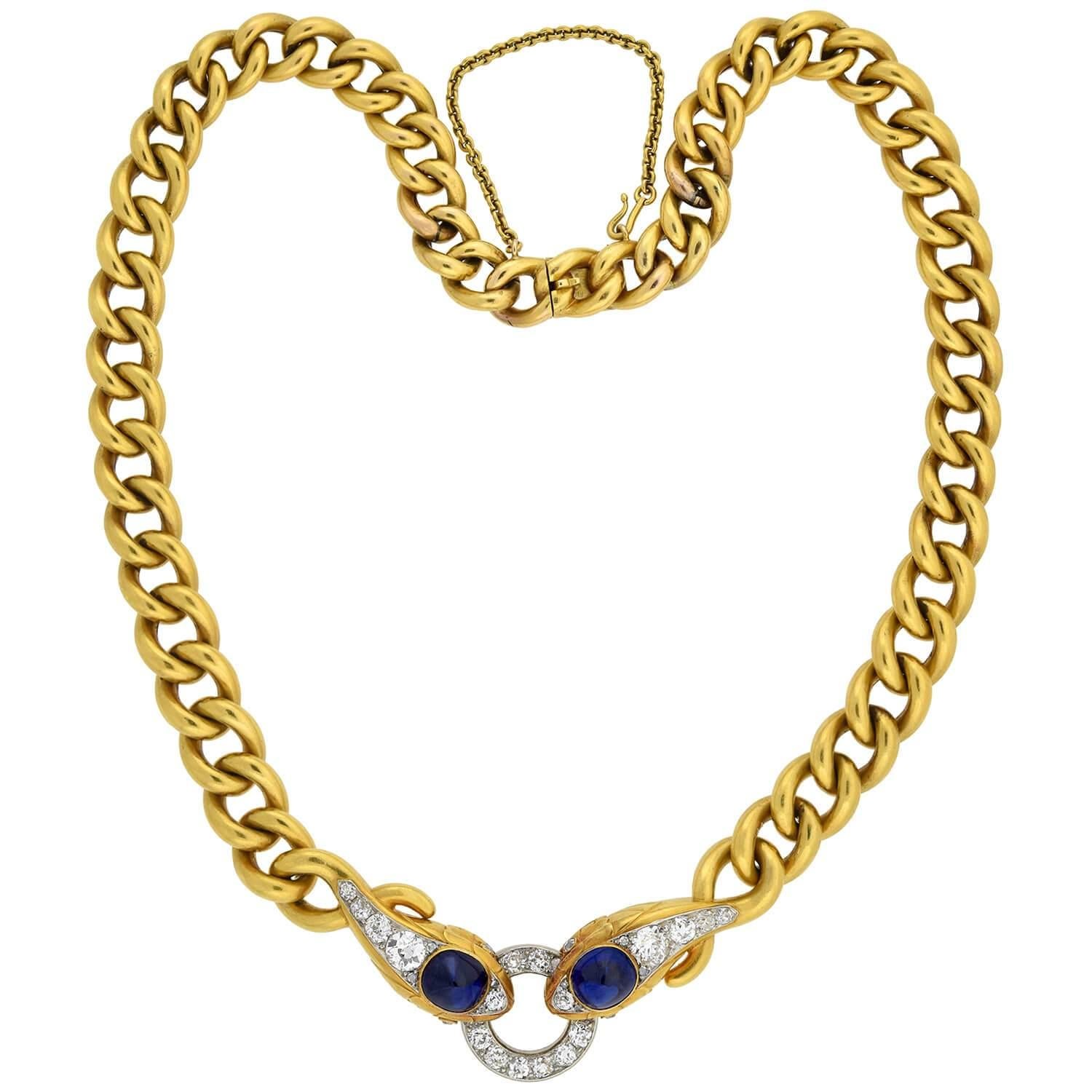 An absolutely spectacular snake necklace from the Edwardian (1910s) era! This exquisite piece is crafted in 18kt yellow gold and platinum and features a double-headed snake motif at the center of a heavy gold chain. The two striking snakes face one