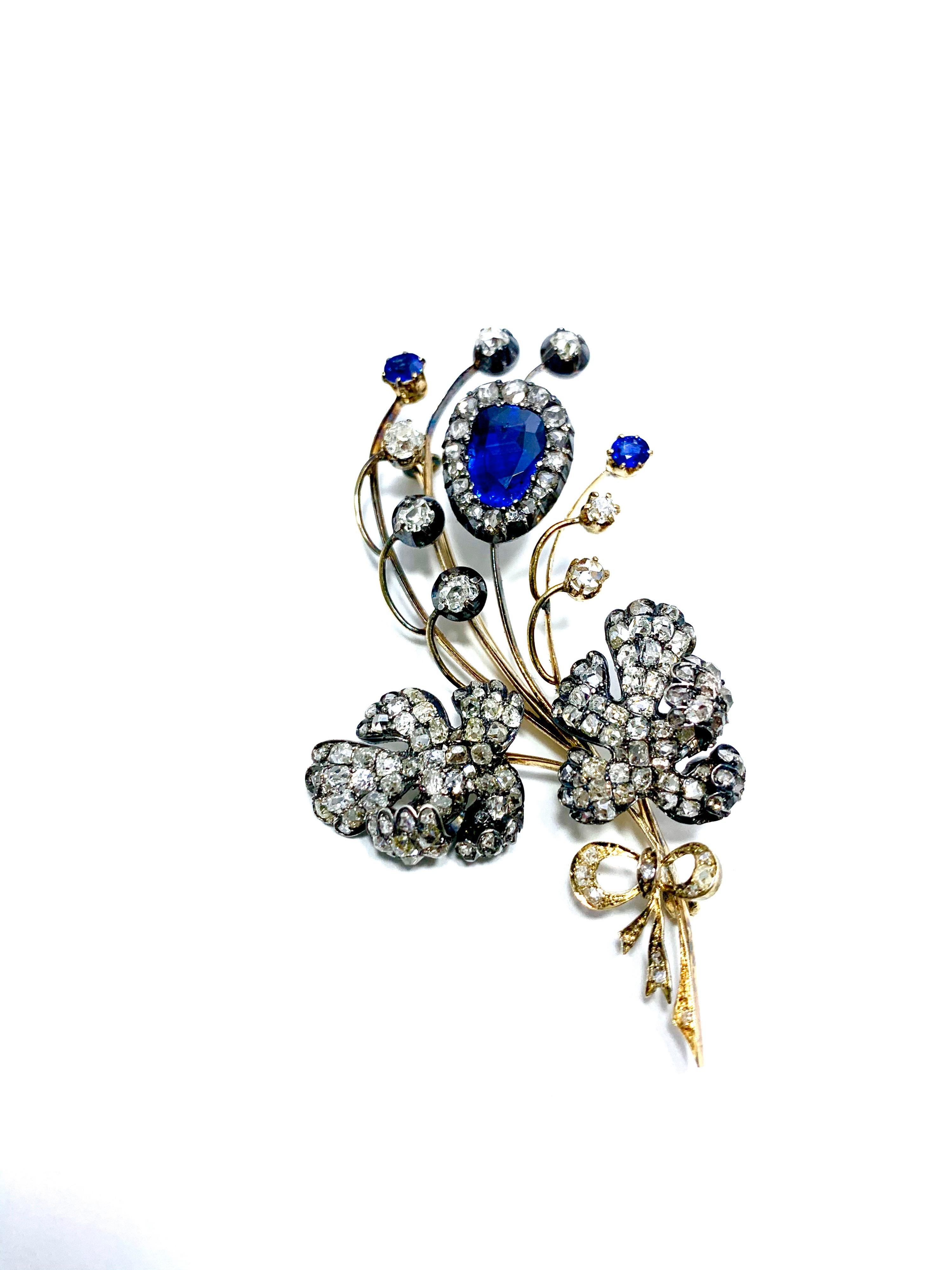 This is a gorgeous one of a kind Edwardian era Sapphire and Diamond silver over gold floral bouquet brooch.  The main royal blue pear shape Sapphire is 3.02 carats, accompanied by two round Sapphires totaling 0.40 carts.  The floral design contains