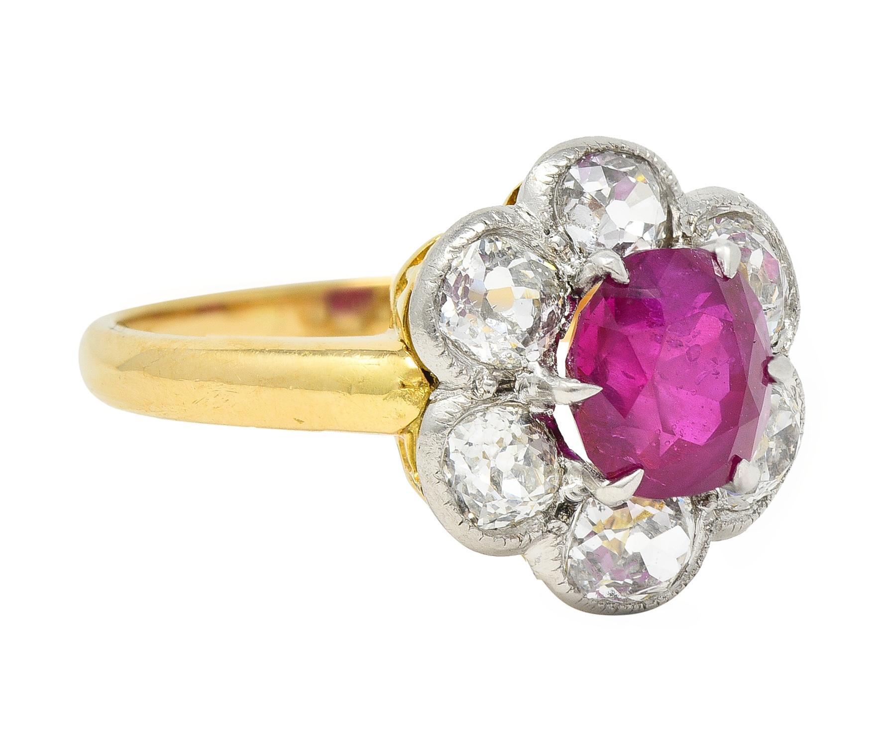 Centering a cushion cut ruby weighing 1.89 carats - transparent bright purplish red in color 
Prong set and natural Burmese in origin with no indications of heat treatment
With a halo surround of bezel set old mine cut diamonds 
Weighing